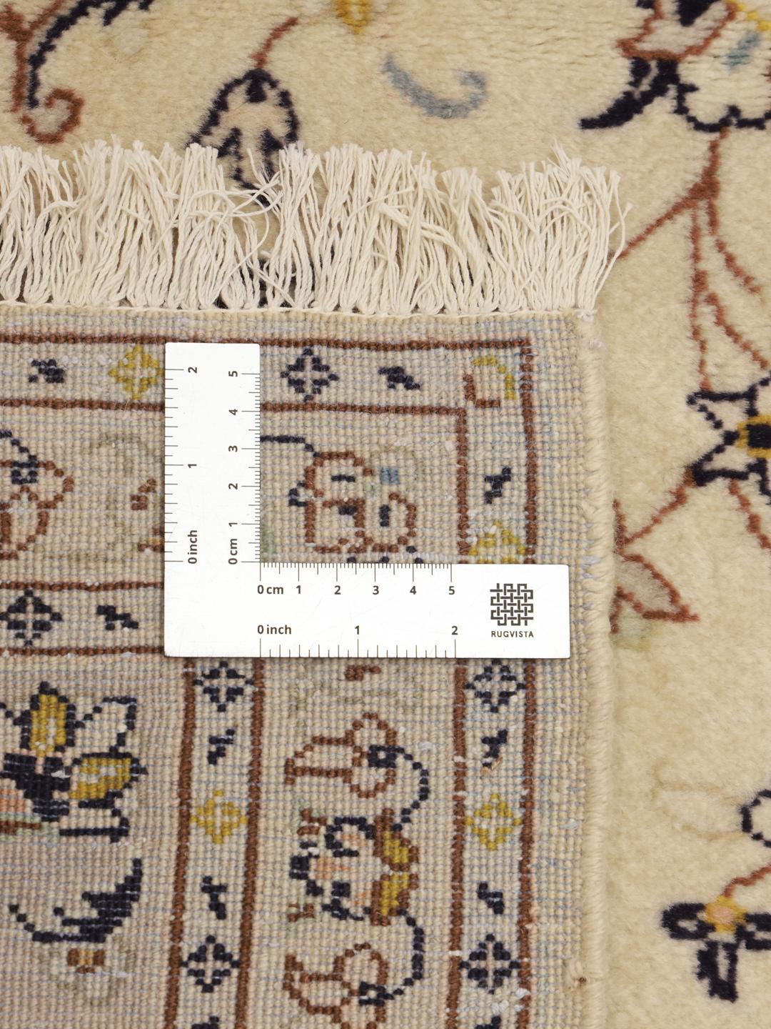 A hand-knotted Keshan rug from the Middle East featuring a beige field with floral patterns.