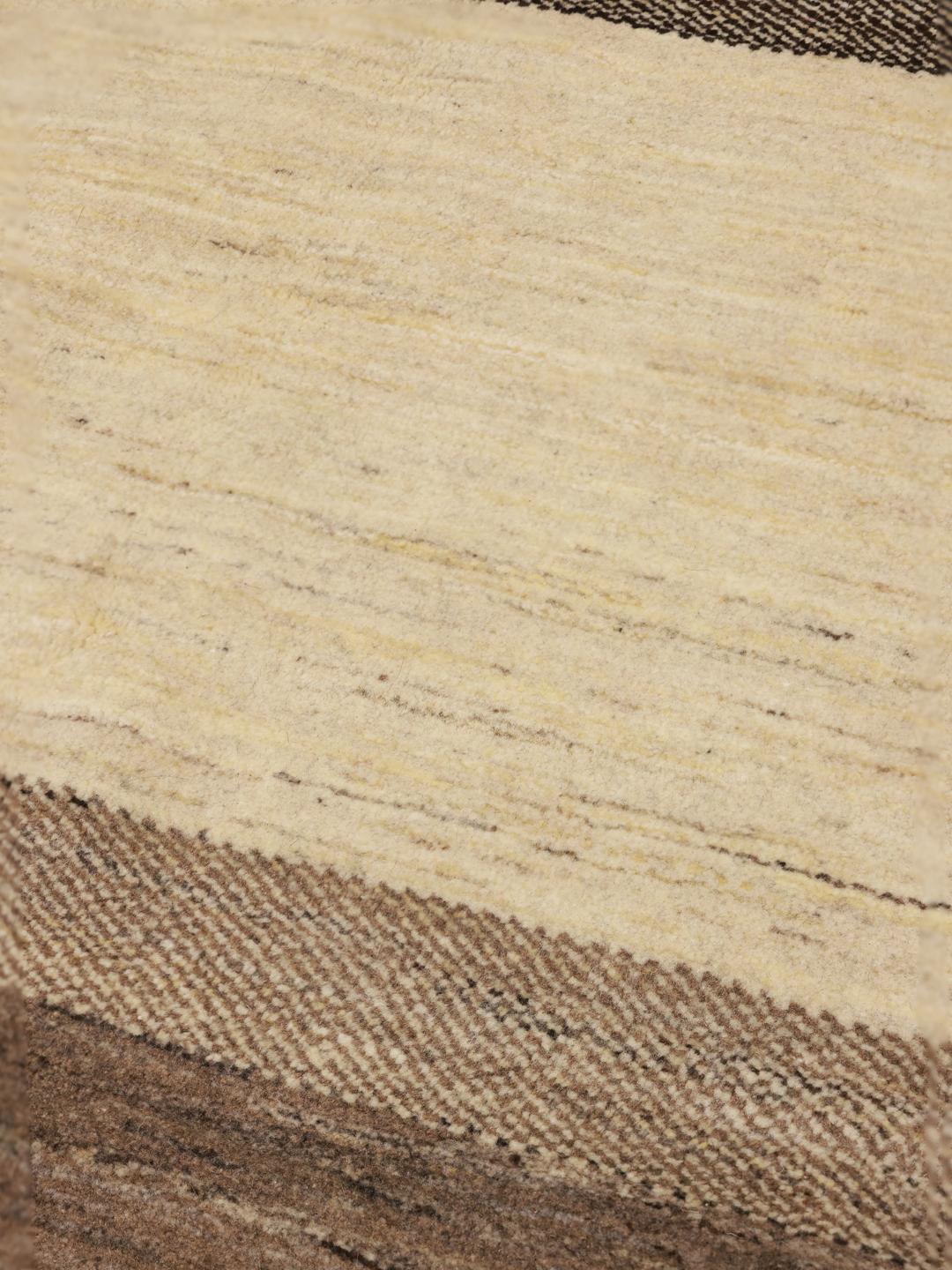 A hand-knotted Gabbeh rug from the Middle East featuring striped earthy brown and beige tones.
