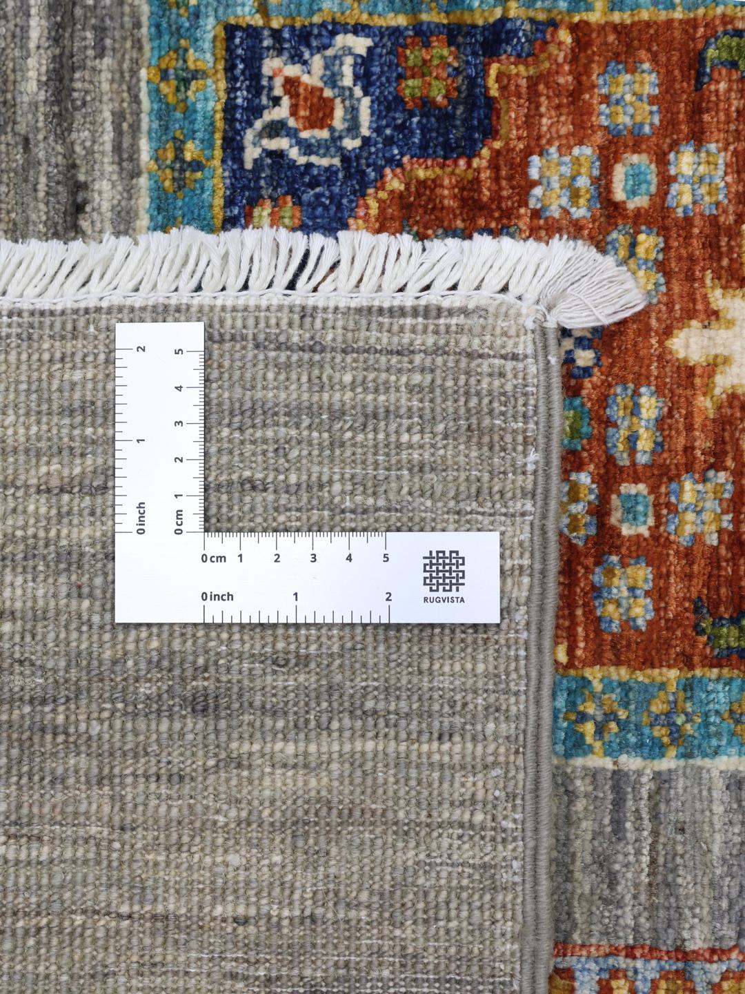 Handgeknoopt Afghaans kleed met kleurrijke motieven op een grijze achtergrond