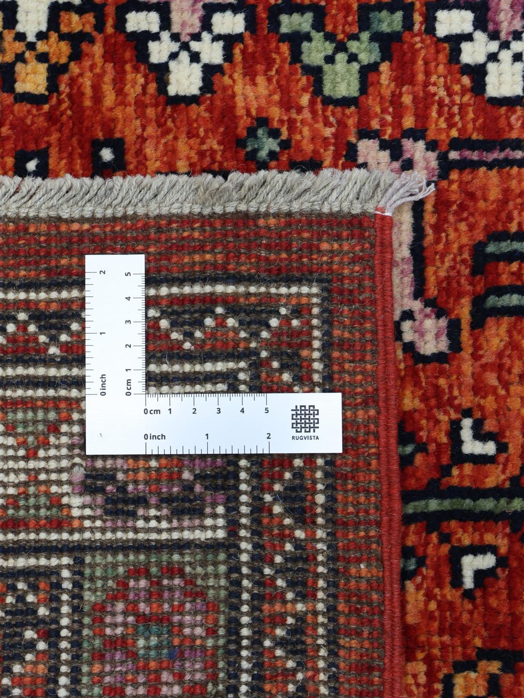 Un covor afgan Kazak înnodat manual, cu un câmp roșu închis și modele geometrice