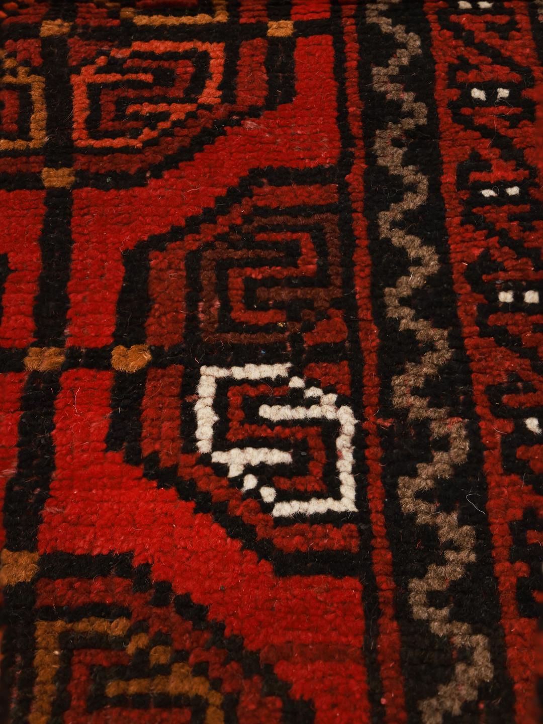 Hand-knotted Turkaman wool rug from the Middle East in dark-red and black