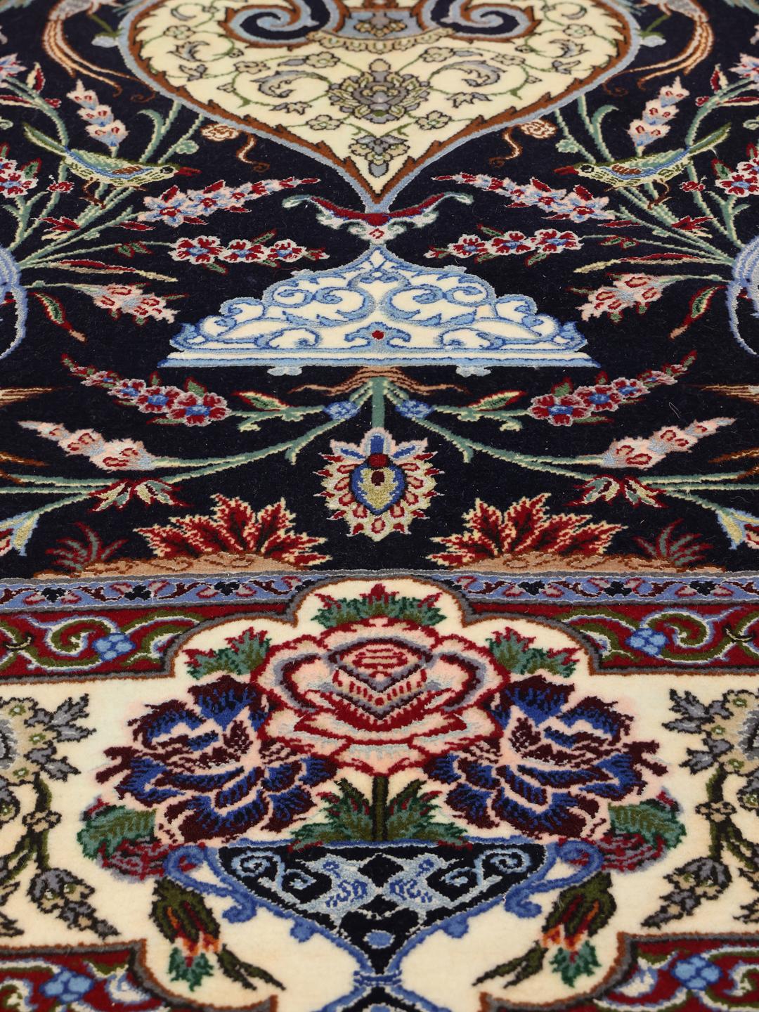 Ručno čvorani Isfahan tepih s motivom detaljne vaze s cvijećem u tamnoplavim i krem tonovima.