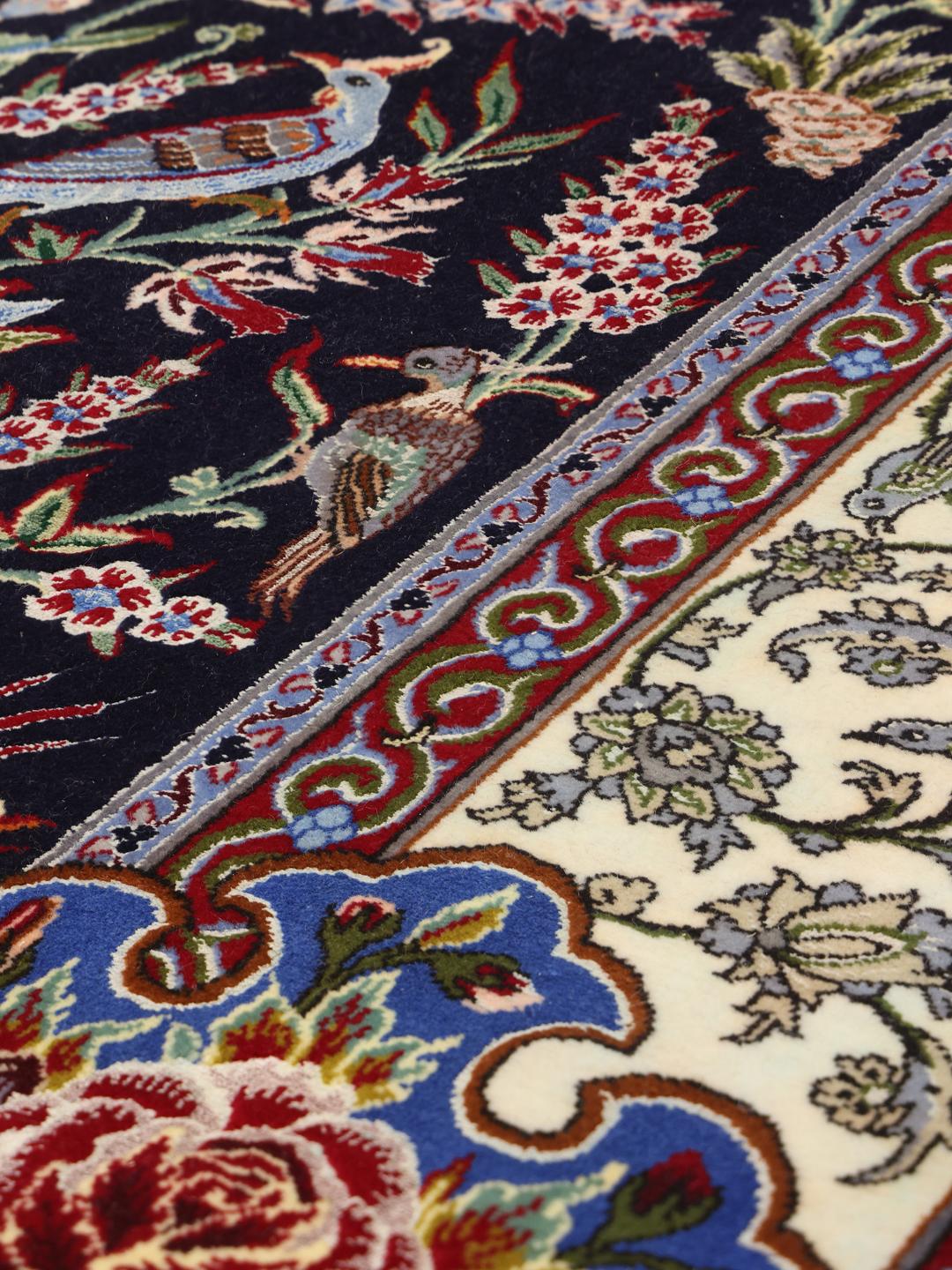 Ručno čvorani Isfahan tepih s motivom detaljne vaze s cvijećem u tamnoplavim i krem tonovima.