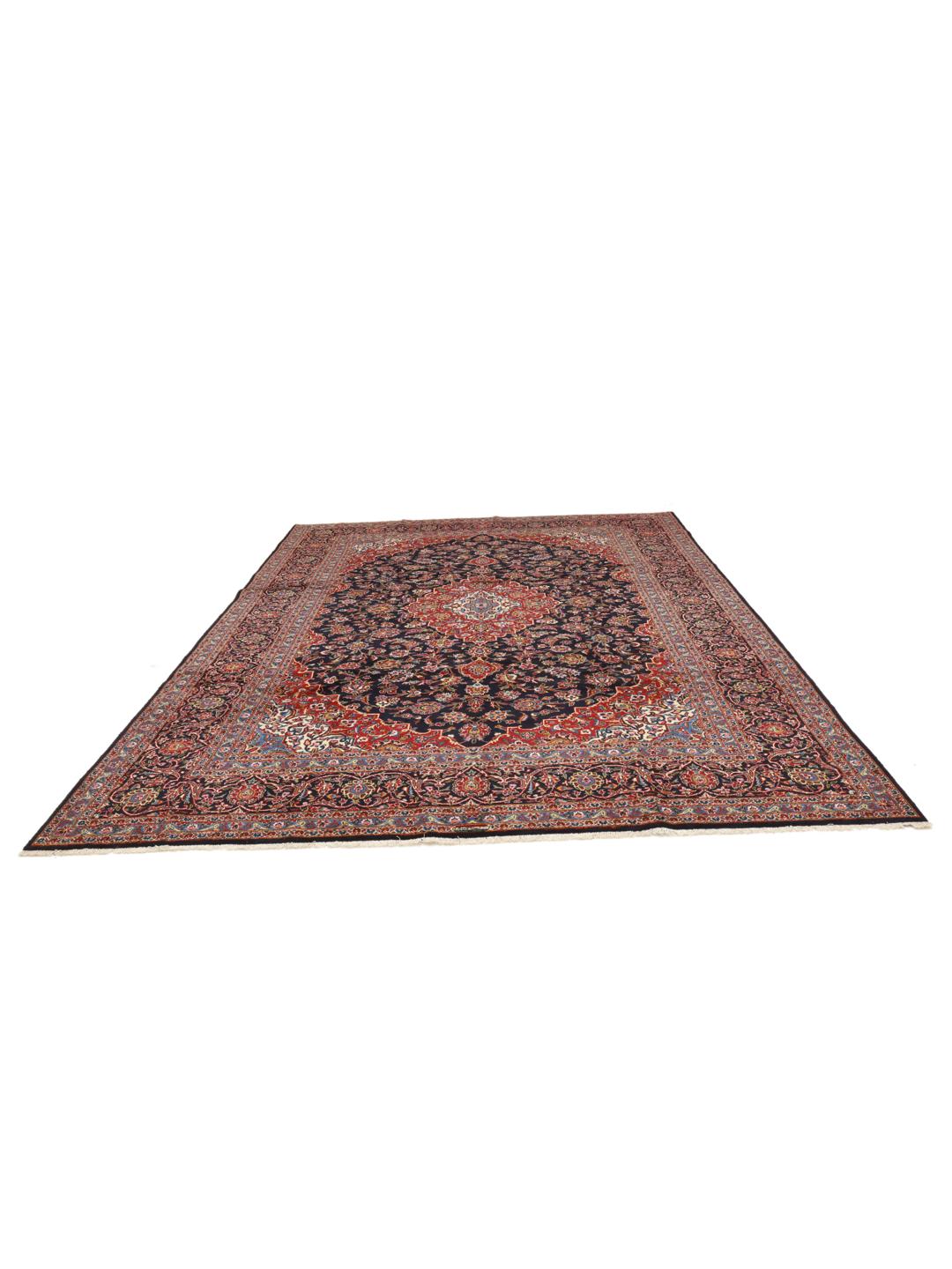 A large rectangular hand-knotted Keshan rug from the Middle East with a dark-blue and dark-red floral pattern.