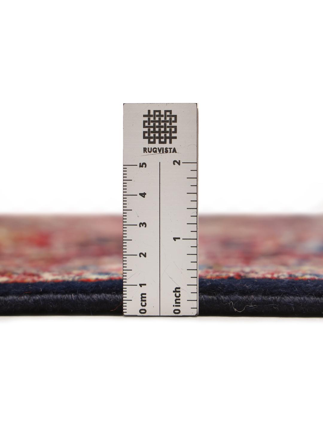 A large rectangular hand-knotted Keshan rug from the Middle East with a dark-blue and dark-red floral pattern.