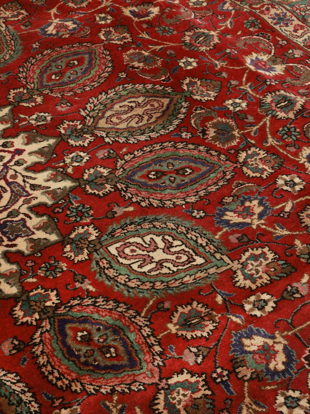 Ein handgeknüpfter Tabriz-Teppich aus dem Nahen Osten in Dunkelrot und bunten Tönen.
