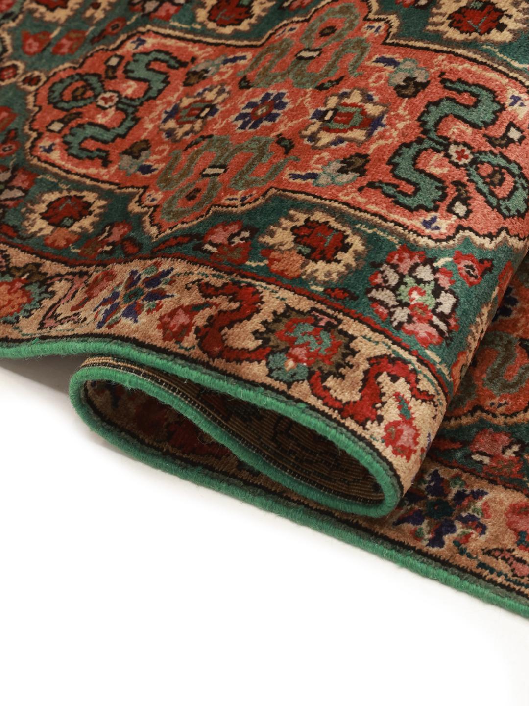 Ein handgeknüpfter Tabriz-Teppich aus dem Nahen Osten in Dunkelrot und bunten Tönen.