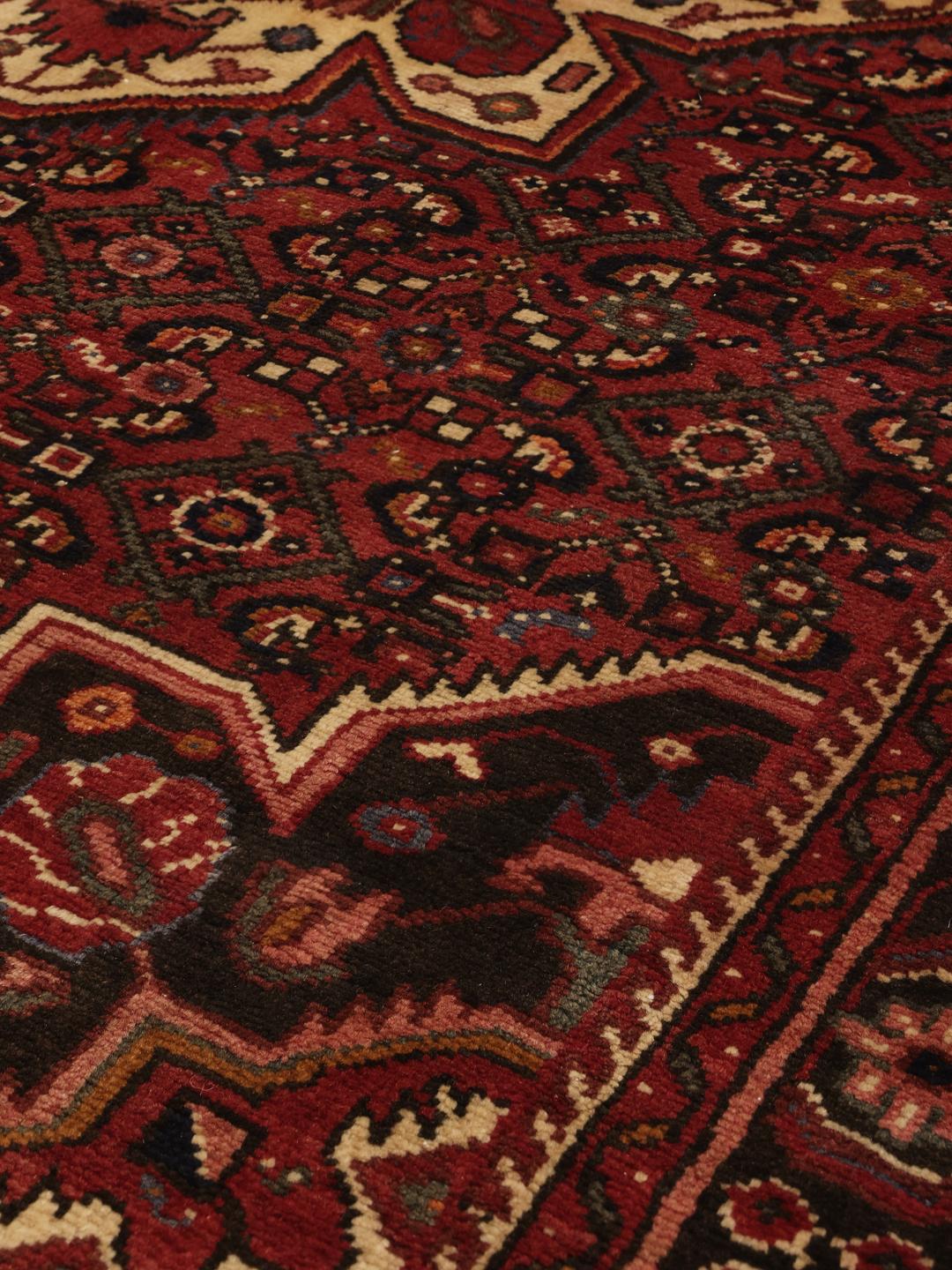 Hand-knotted Hosseinabad rug from the Middle East in dark-red tones