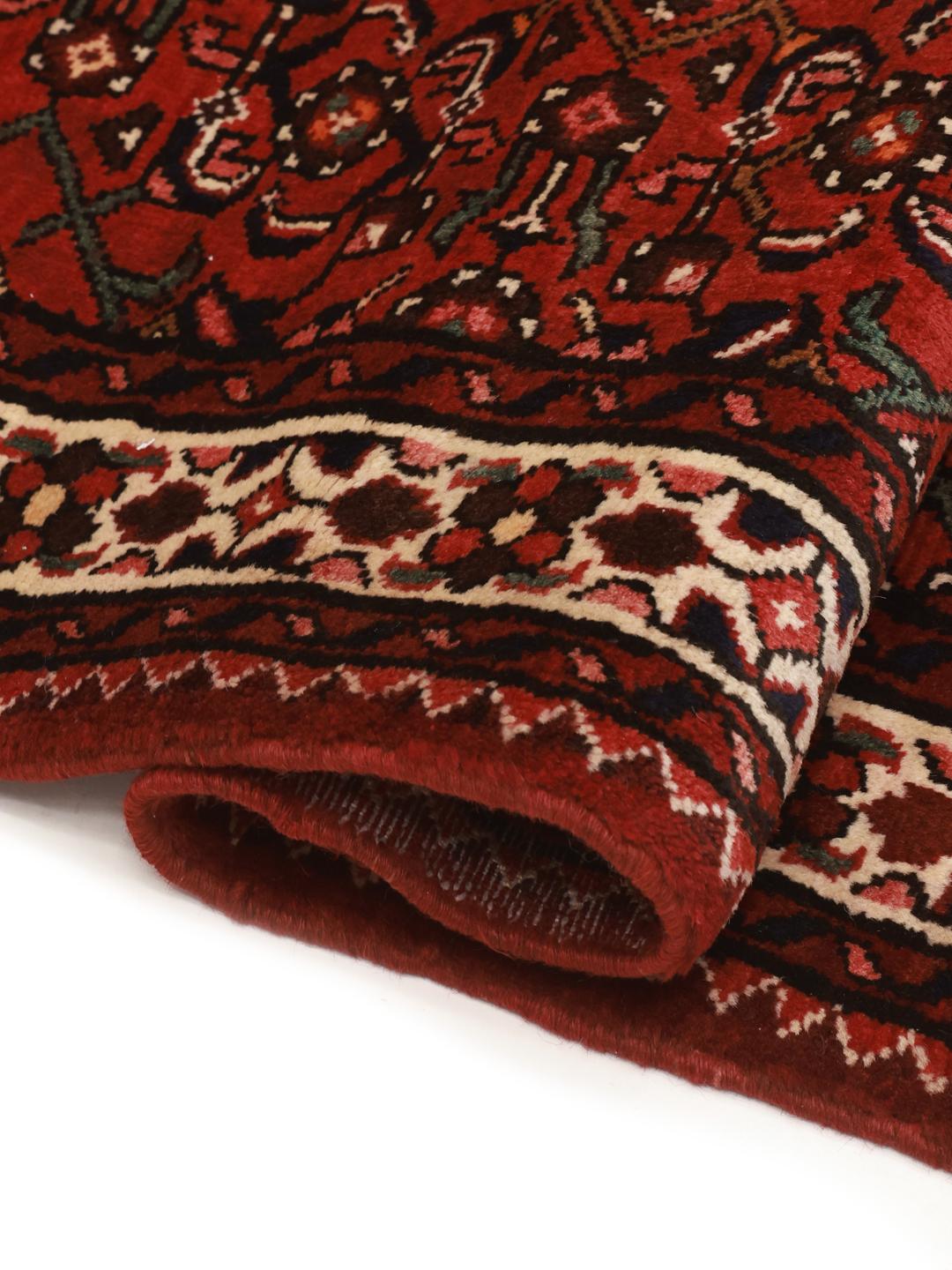 Hand-knotted Hosseinabad runner in red featuring traditional patterns.