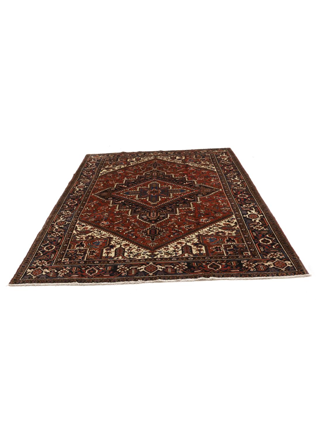 A hand-knotted Heriz rug from the Middle East featuring a vibrant red and blue geometric medallion design.