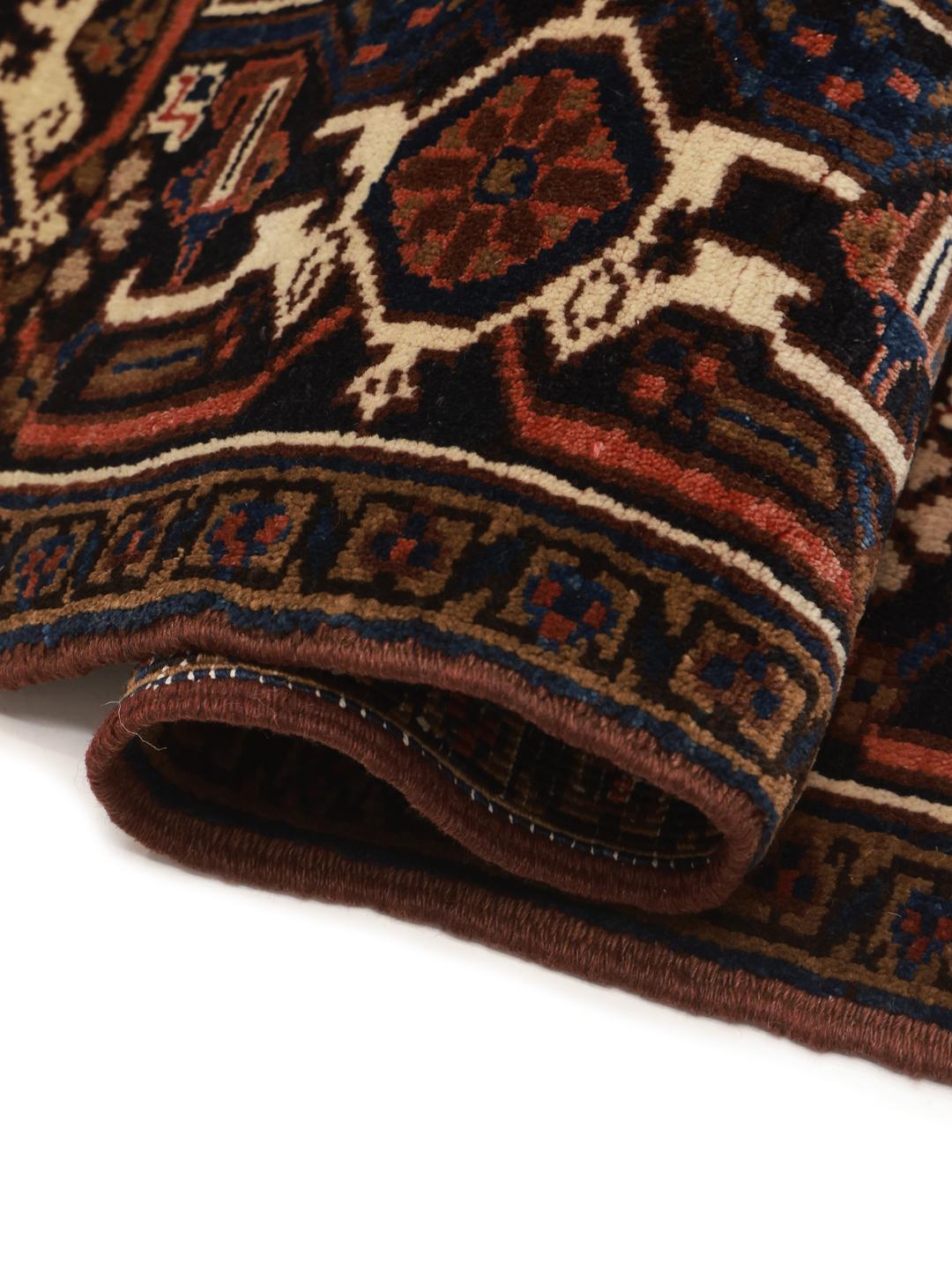 A hand-knotted Heriz rug from the Middle East featuring a vibrant red and blue geometric medallion design.