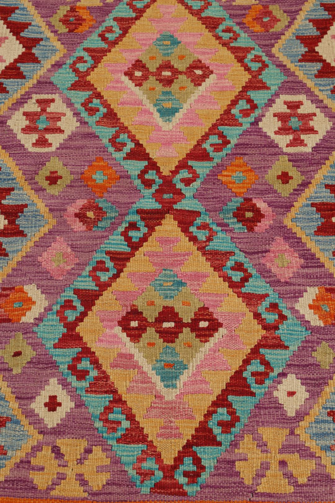 Hand-woven Afghan Kelim rug featuring geometric patterns in orange, purple, and blue.