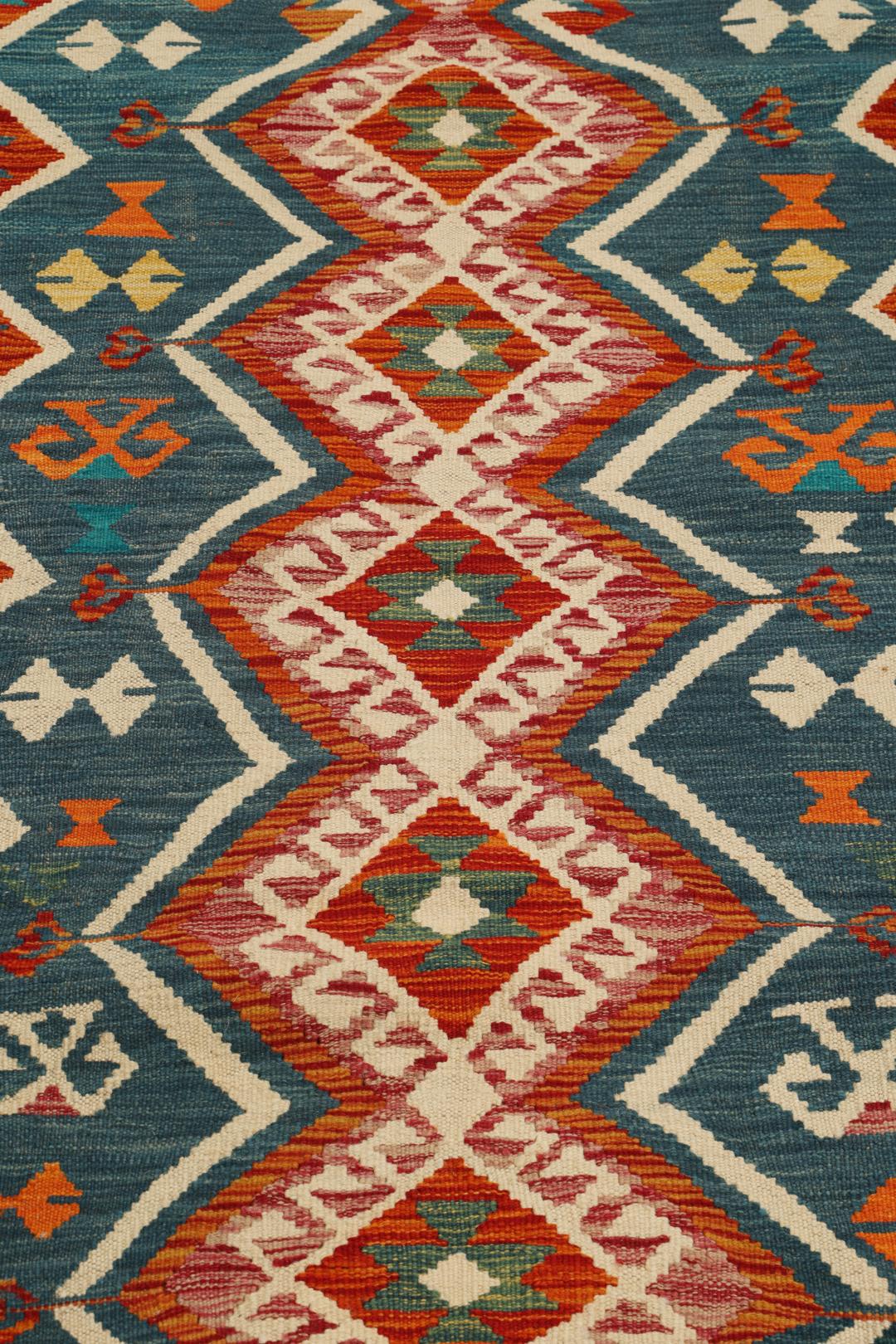A rectangular, hand-woven Kelim Afghan rug featuring geometric patterns in blue, red, and orange tones.