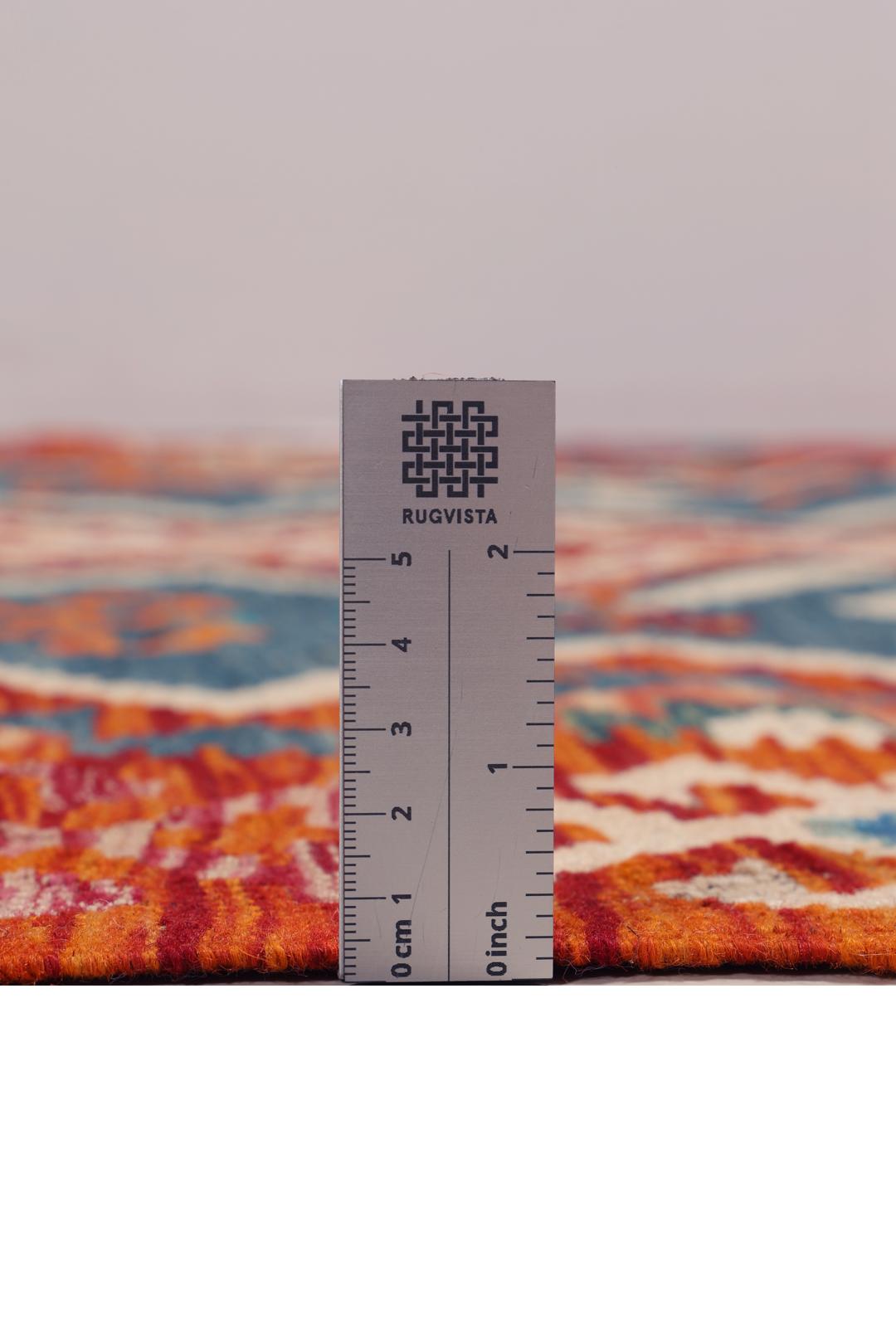 A rectangular, hand-woven Kelim Afghan rug featuring geometric patterns in blue, red, and orange tones.