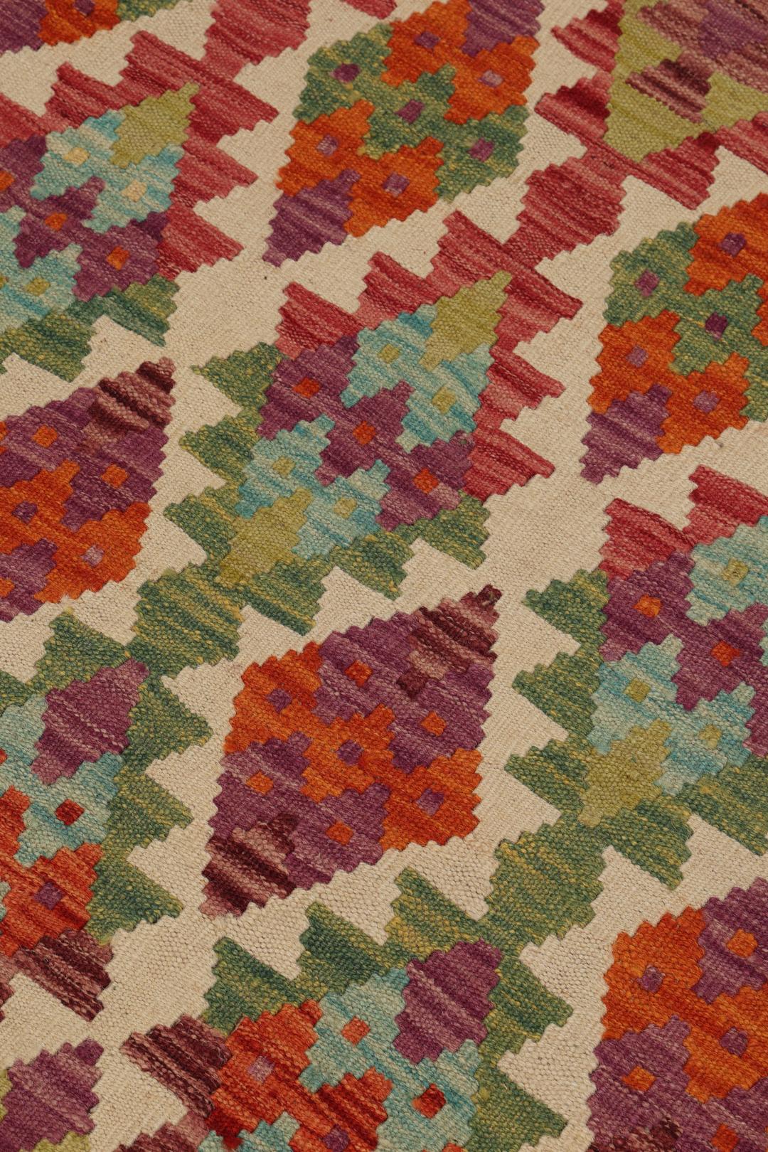Hand-woven Afghan Kelim rug featuring a vibrant, multi-coloured geometric diamond pattern.