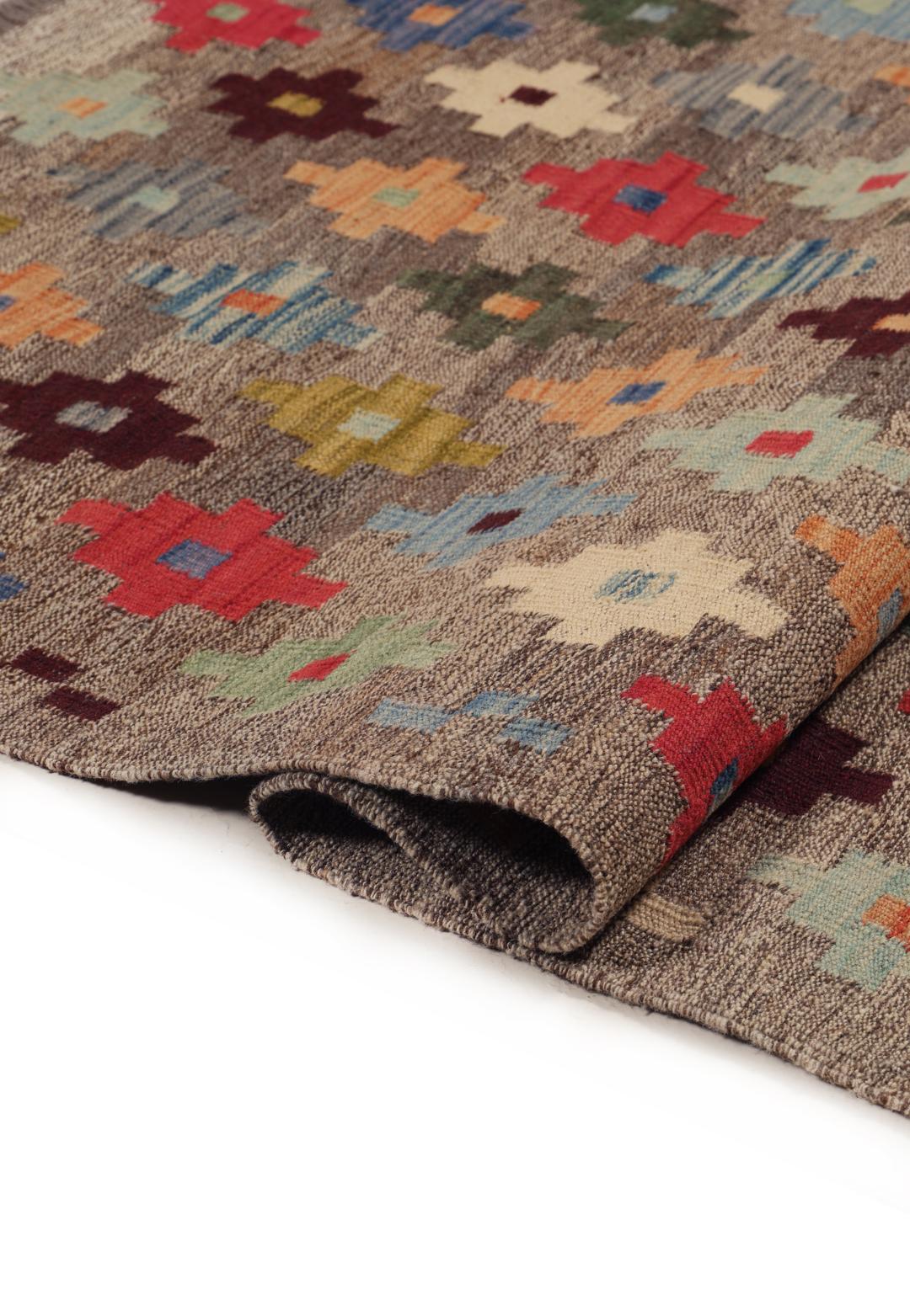 Hand-woven Afghan kelim rug with colourful geometric motifs on a grey background