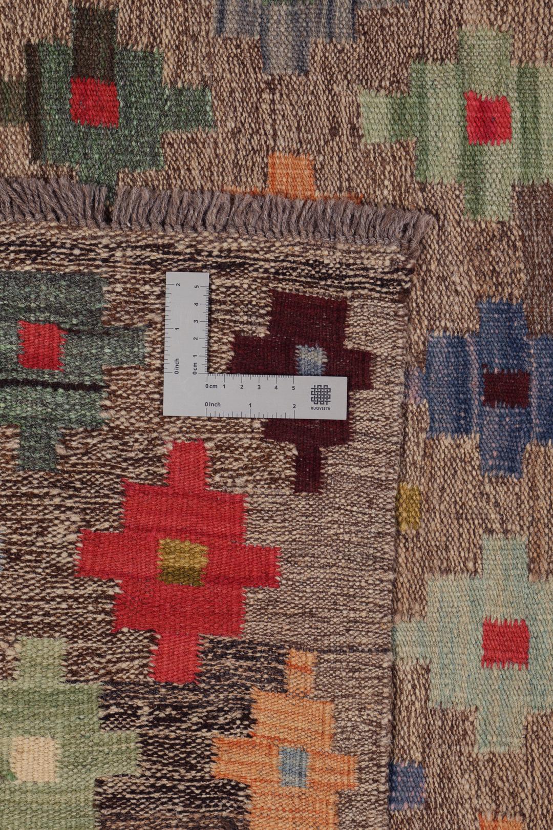Hand-woven Afghan kelim rug with colourful geometric motifs on a grey background