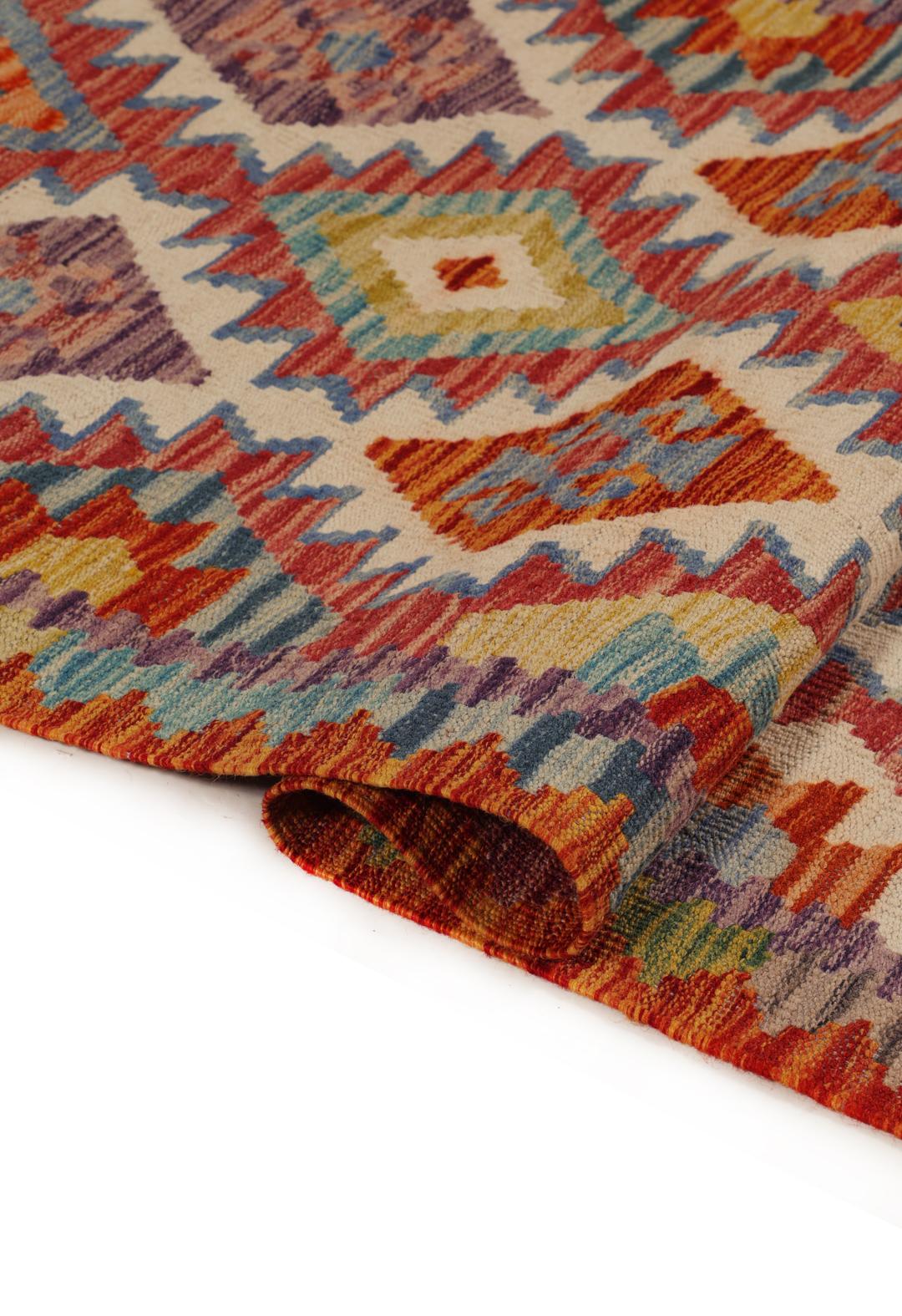A hand-woven Afghan runner rug with a multicolor diamond pattern on a light background