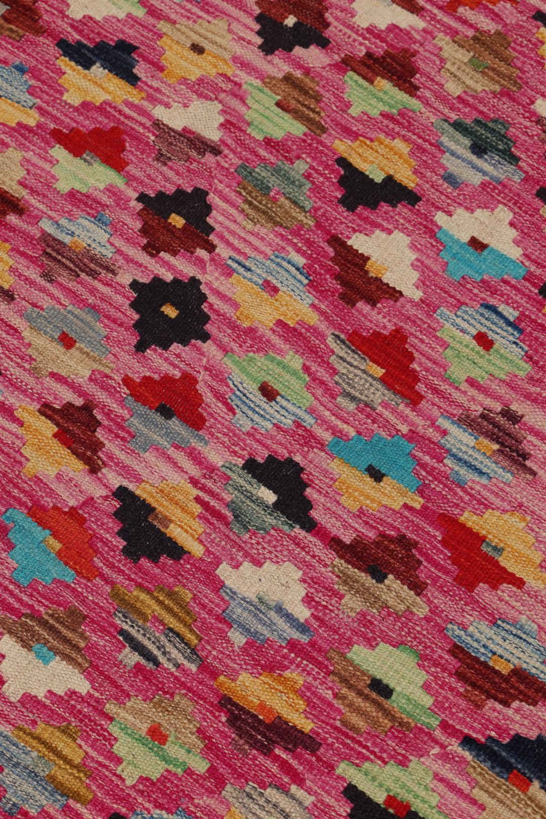 Handgeweven Afghan Kelim tapijt met een levendig roze veld en een geometrisch ruitpatroon