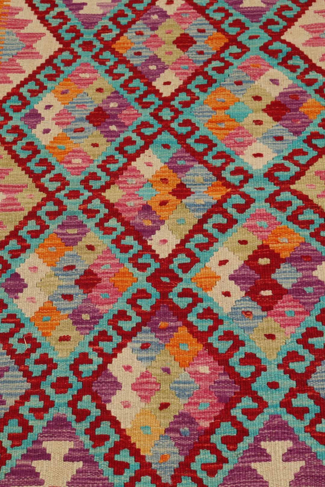 Hand-woven Afghan Kelim rug with vibrant geometric patterns in orange, teal, and purple