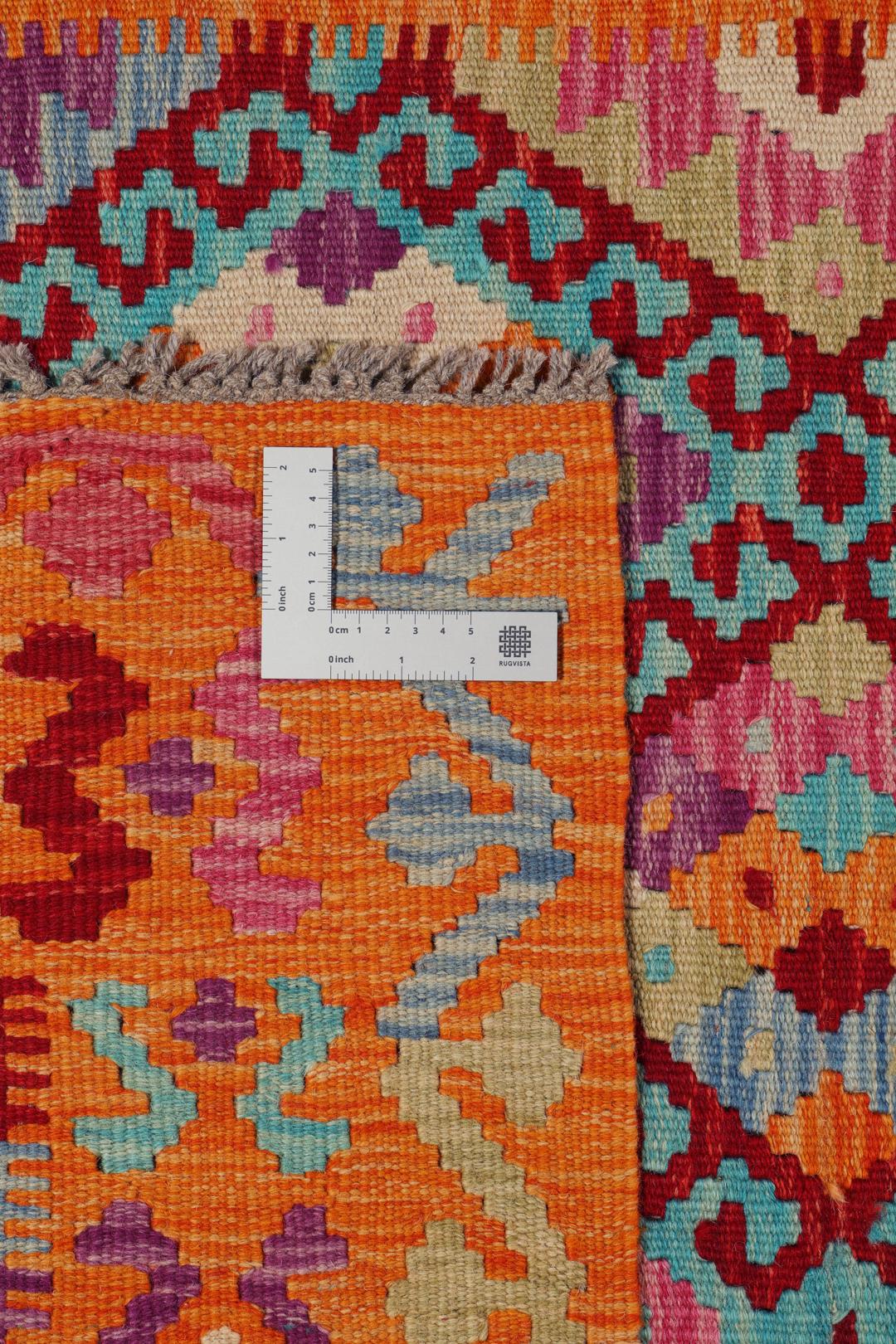 Hand-woven Afghan Kelim rug with vibrant geometric patterns in orange, teal, and purple