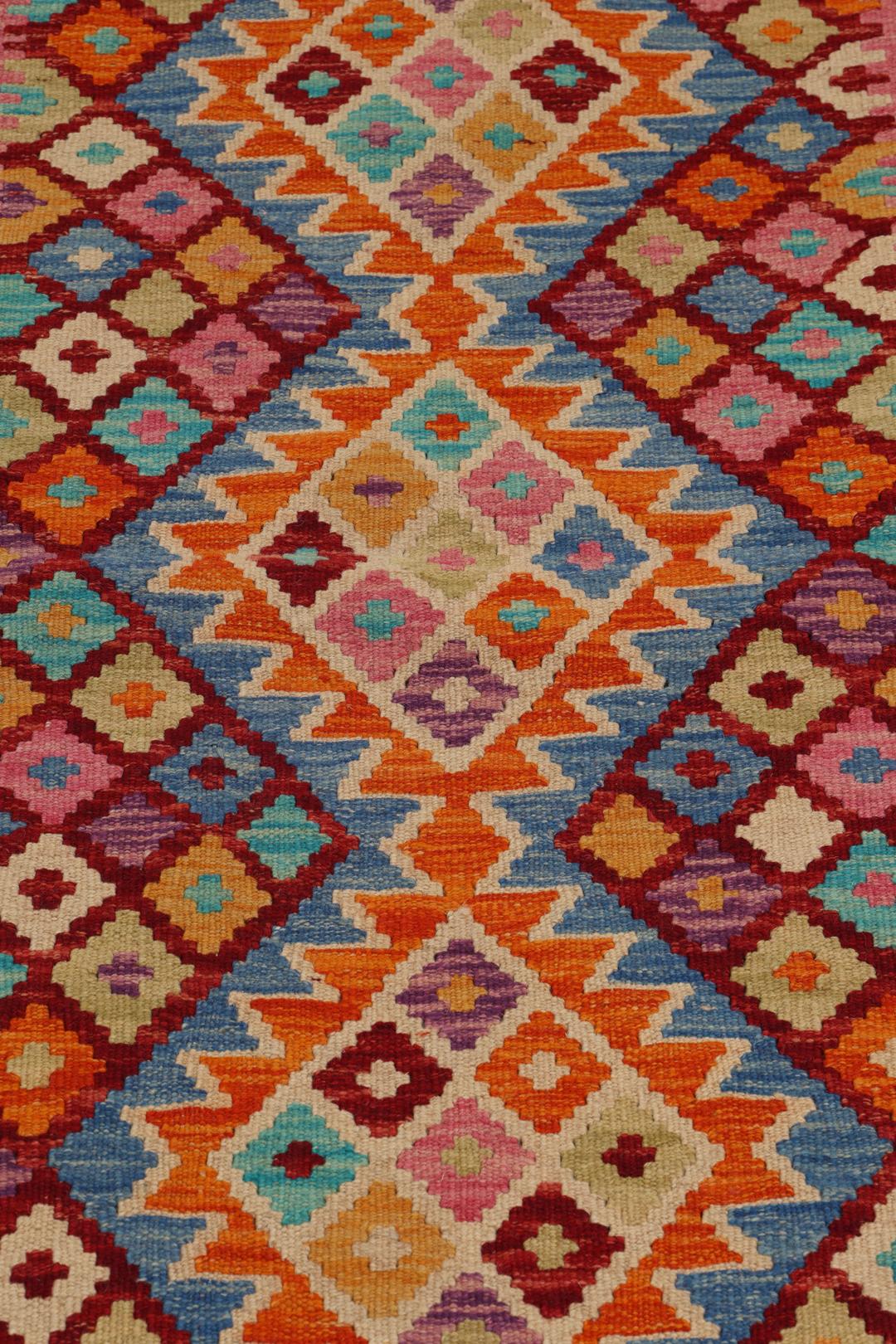 Hand-woven Afghan Kelim rug with vibrant geometric patterns in multicolor.
