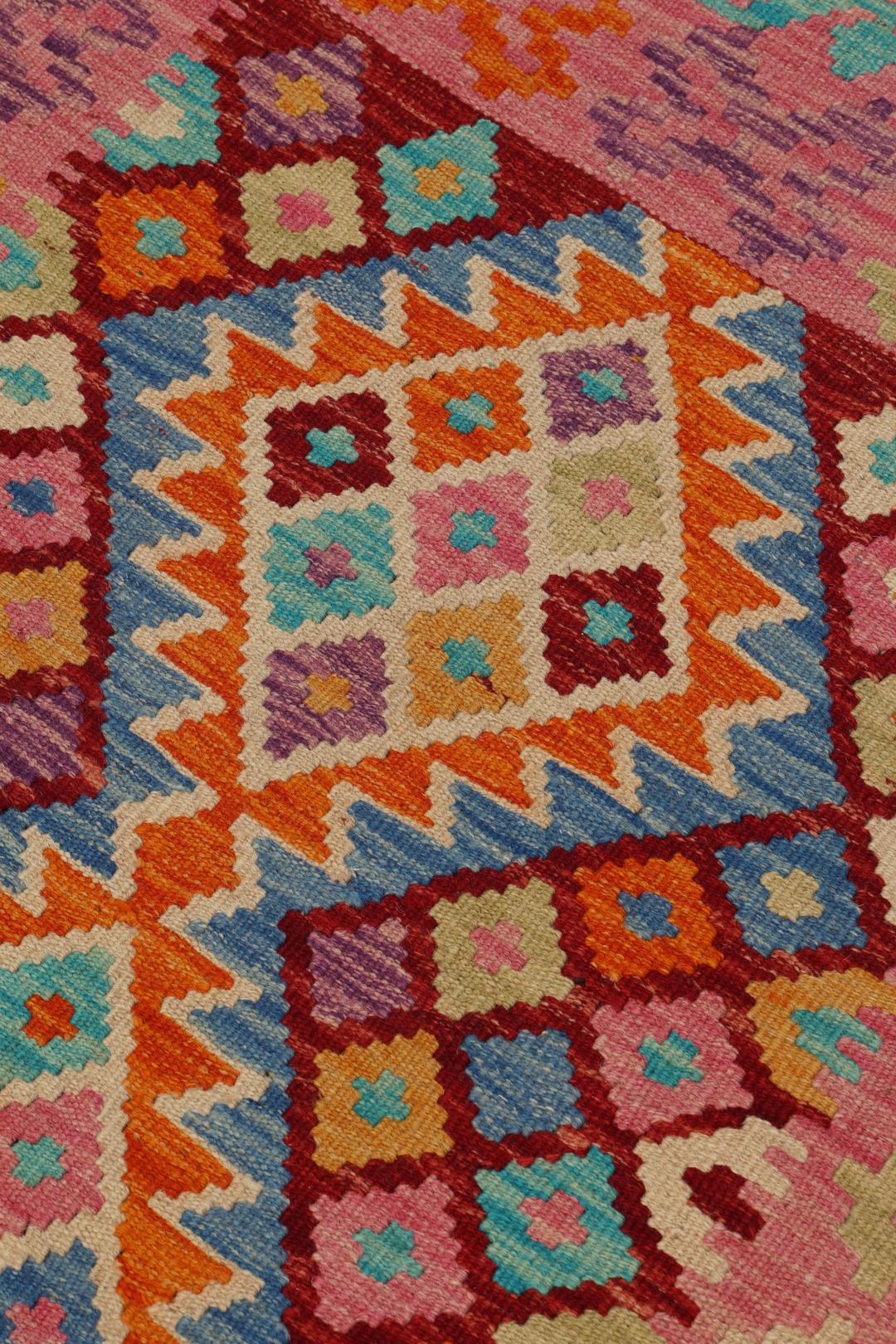 Hand-woven Afghan Kelim rug with vibrant geometric patterns in multicolor.