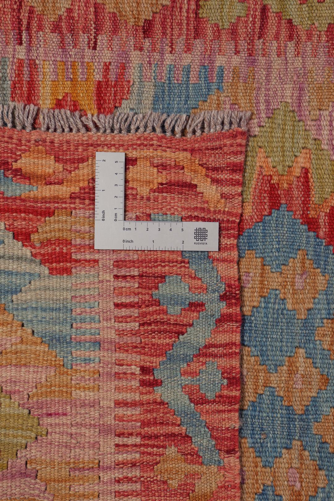 A hand-woven multicoloured Afghan runner with geometric diamond motifs.