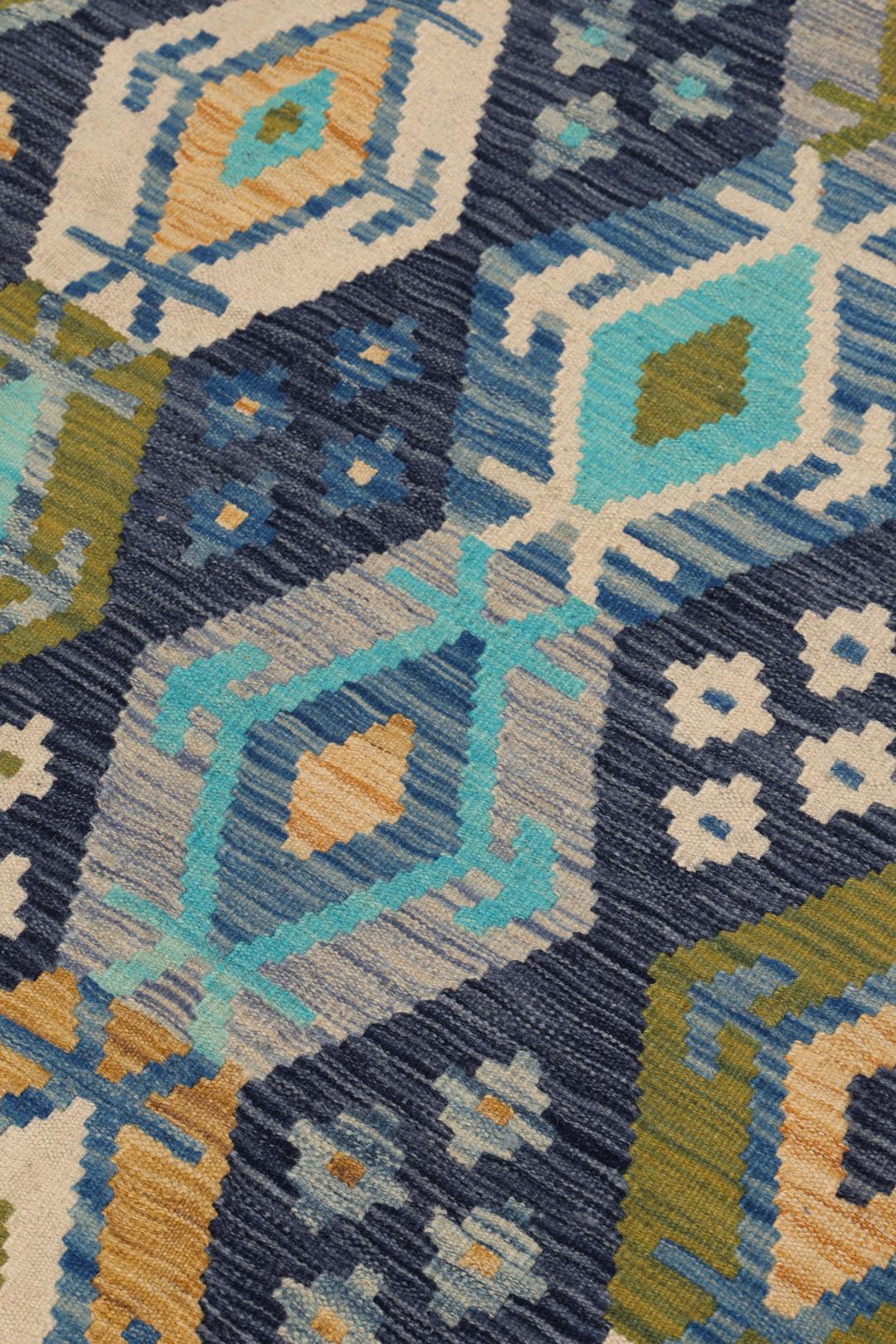 Hand-woven Afghan Kelim rug in shades of blue and teal with geometric diamond patterns