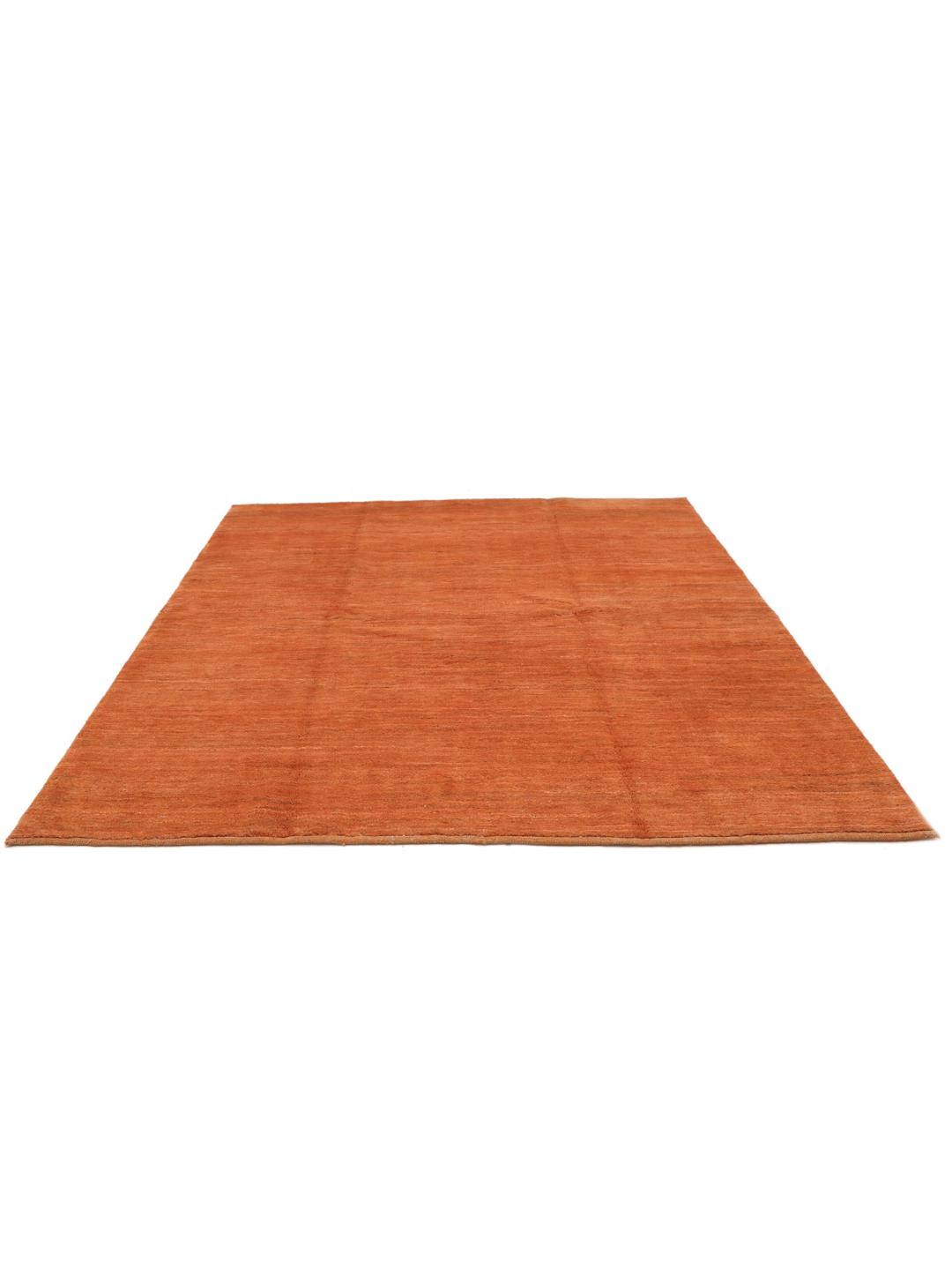 Een vierkant, oranje, handgeknoopt Gabbeh-kleed uit het Midden-Oosten.