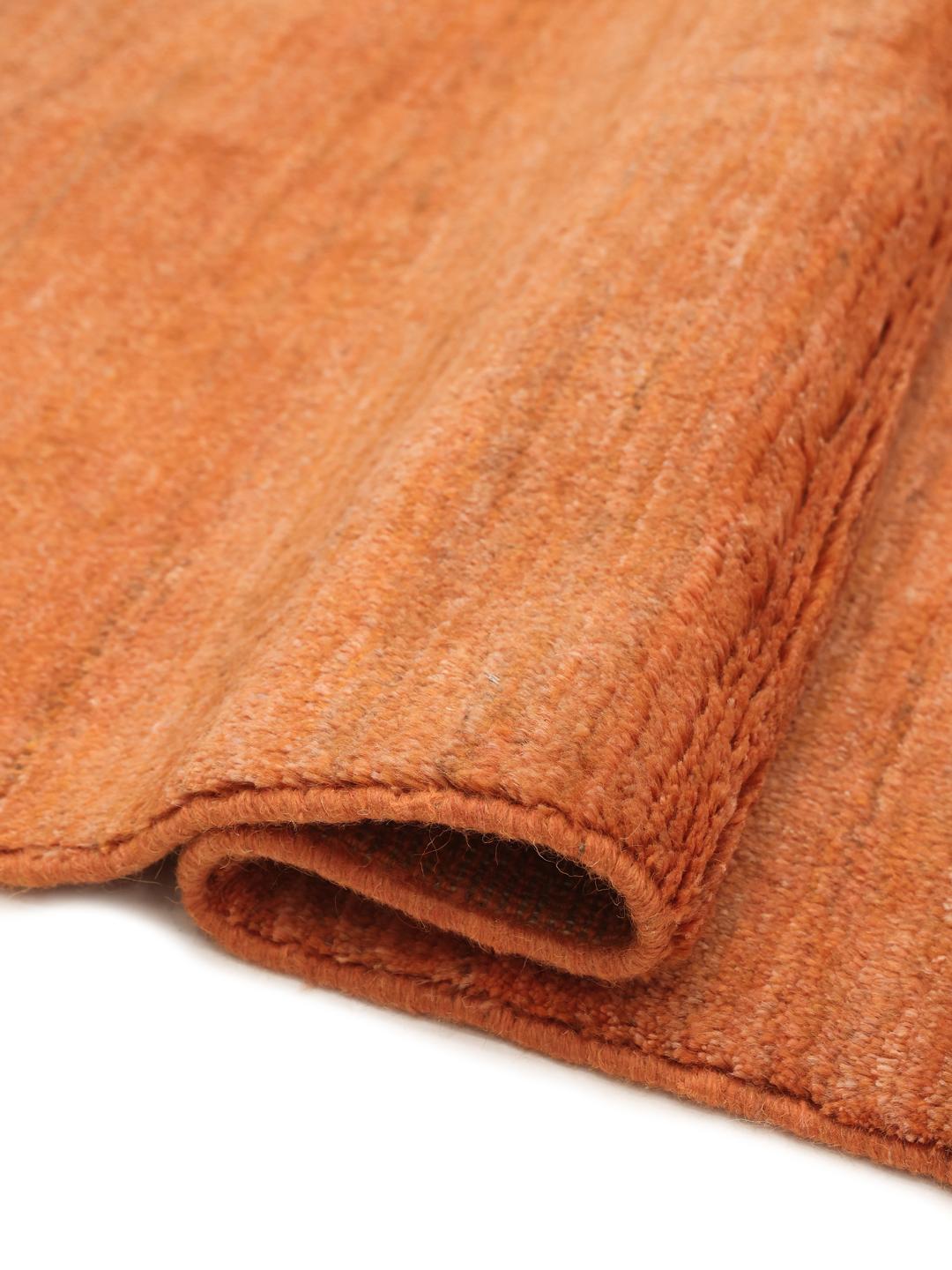 Een vierkant, oranje, handgeknoopt Gabbeh-kleed uit het Midden-Oosten.