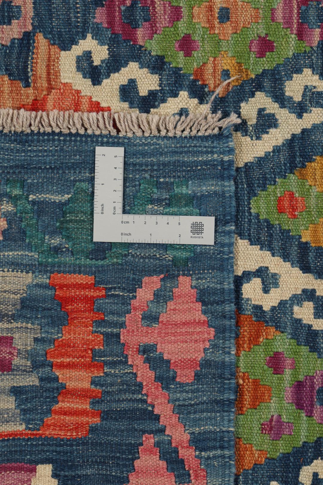 Hand-woven Afghan Kelim rug with a multicolor diamond pattern on a blue background