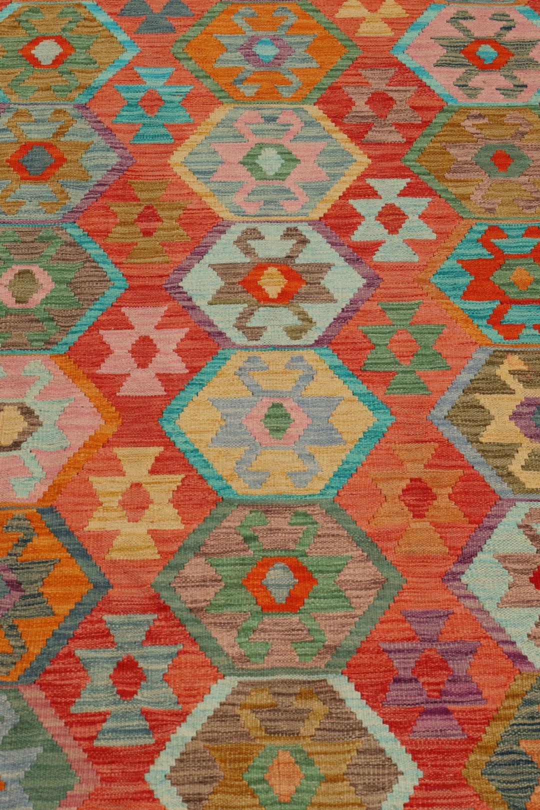 Handmade Kelim rug from Afghanistan with a colourful geometric pattern in red and multicolour tones.