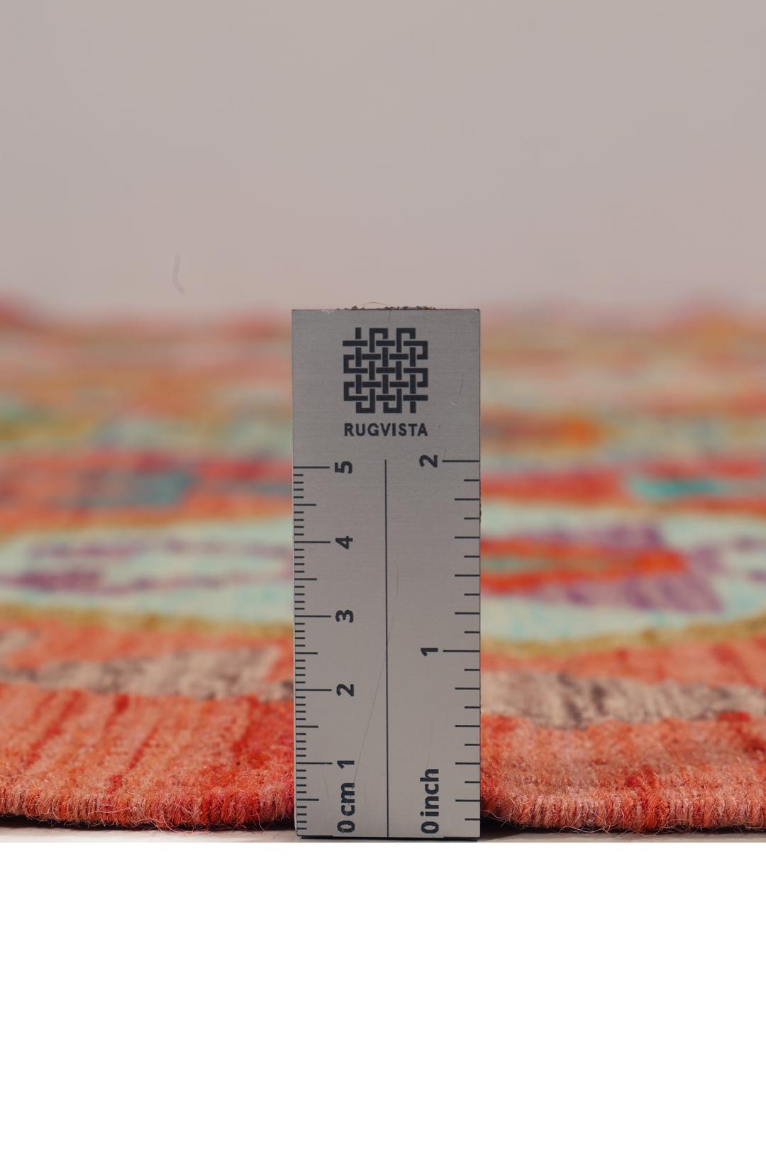 Handmade Kelim rug from Afghanistan with a colourful geometric pattern in red and multicolour tones.