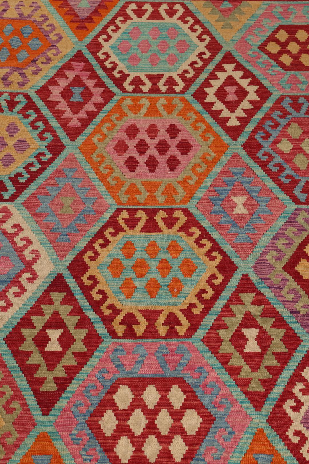 Een groot, rechthoekig handgeweven Afghan Kelim kleed met een kleurrijk geometrisch honingraatpatroon.