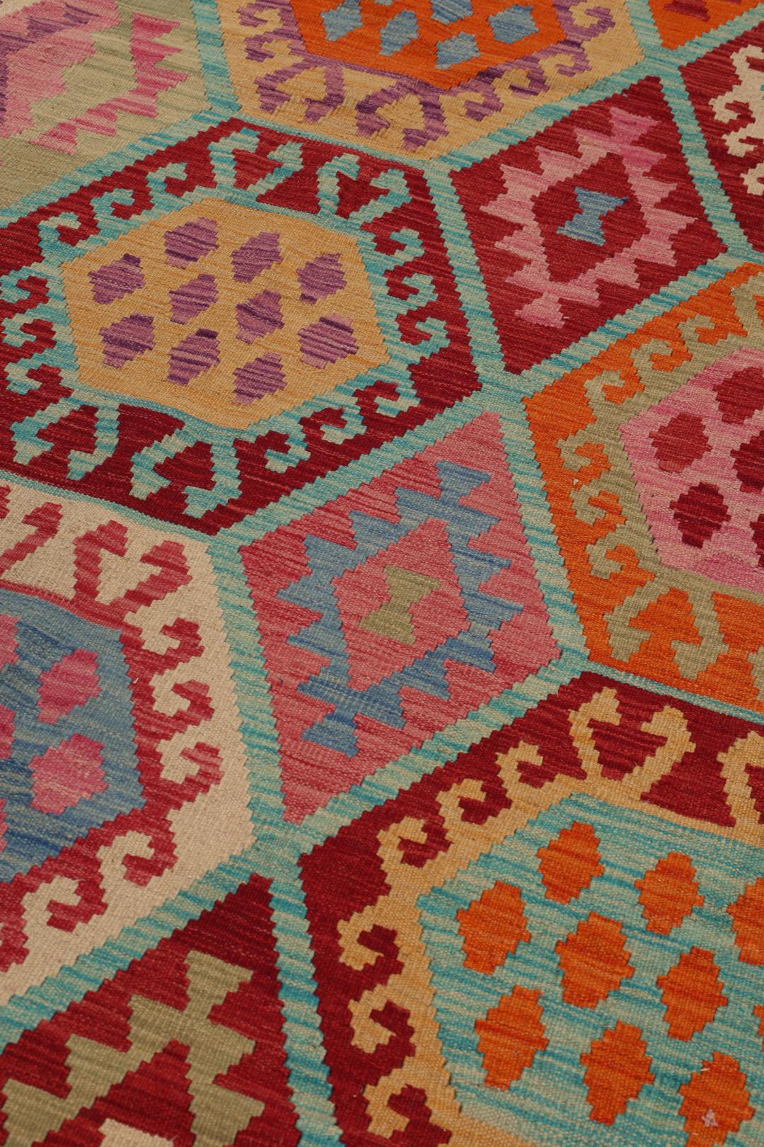 Een groot, rechthoekig handgeweven Afghan Kelim kleed met een kleurrijk geometrisch honingraatpatroon.