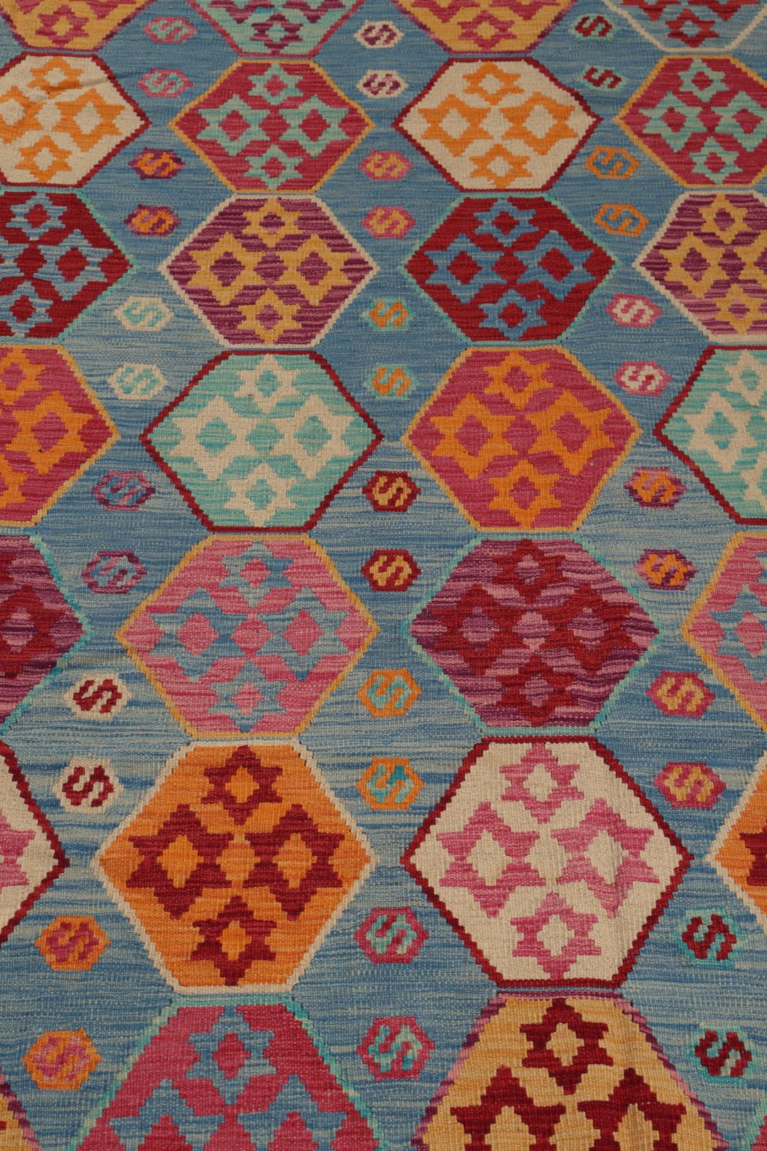 Et håndvævet Kelim Afghan Old Style-tæppe med farverige geometriske mønstre på en blå baggrund.