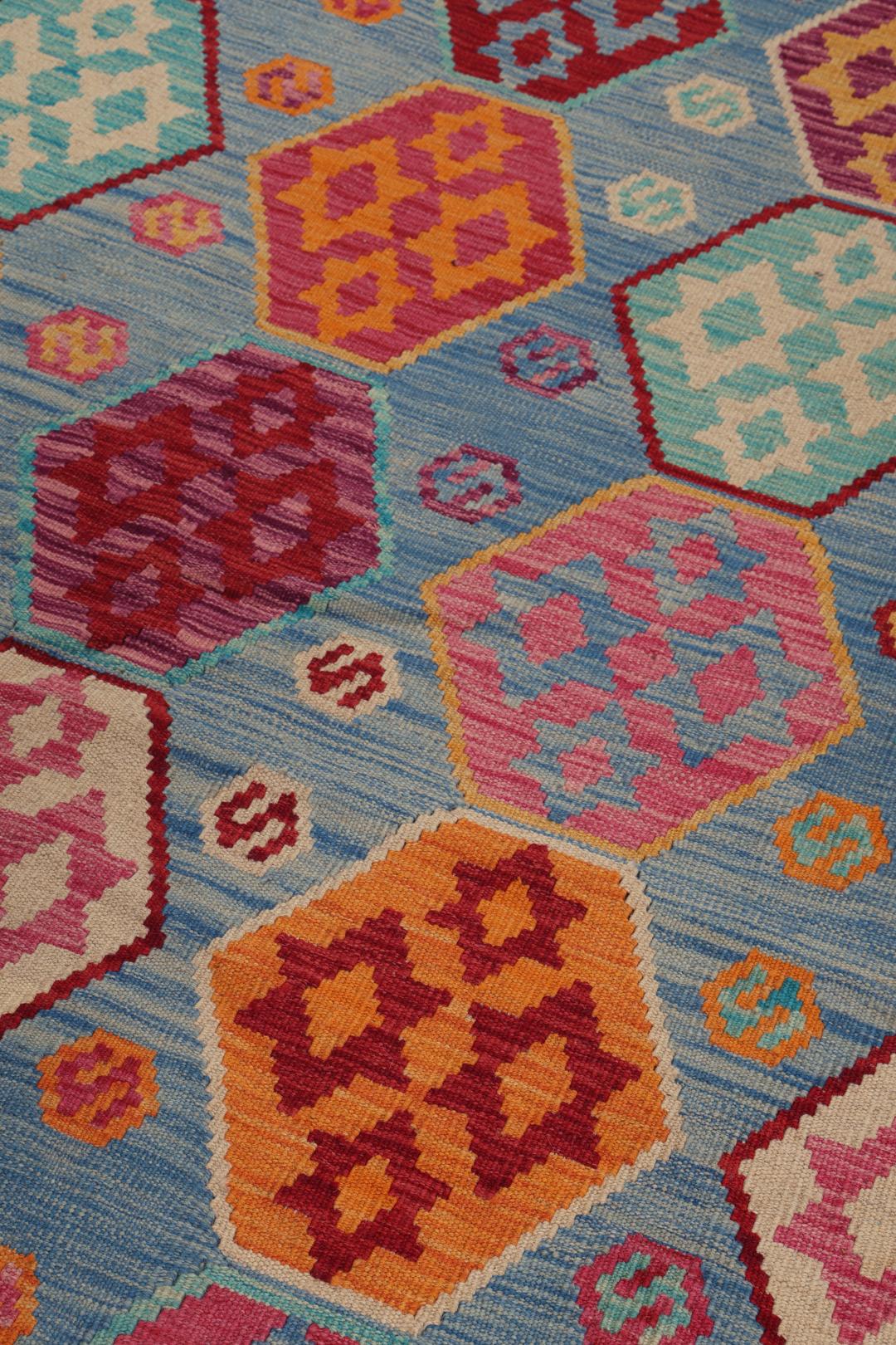Et håndvævet Kelim Afghan Old Style-tæppe med farverige geometriske mønstre på en blå baggrund.