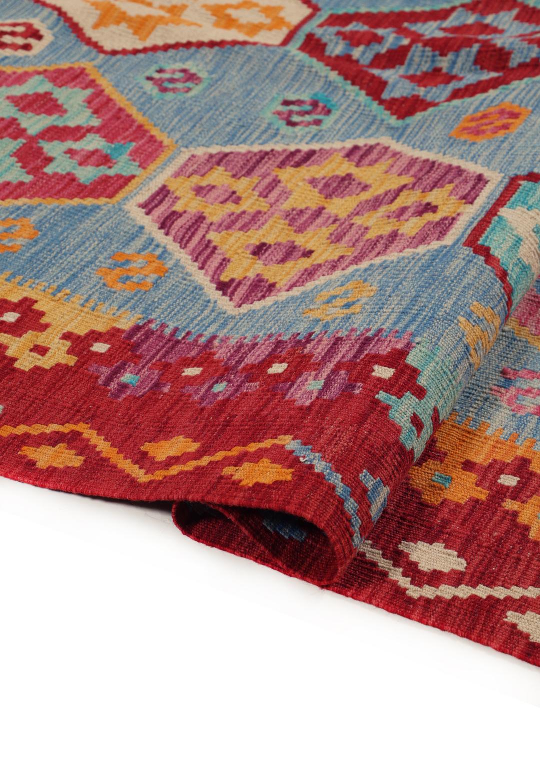 Et håndvævet Kelim Afghan Old Style-tæppe med farverige geometriske mønstre på en blå baggrund.