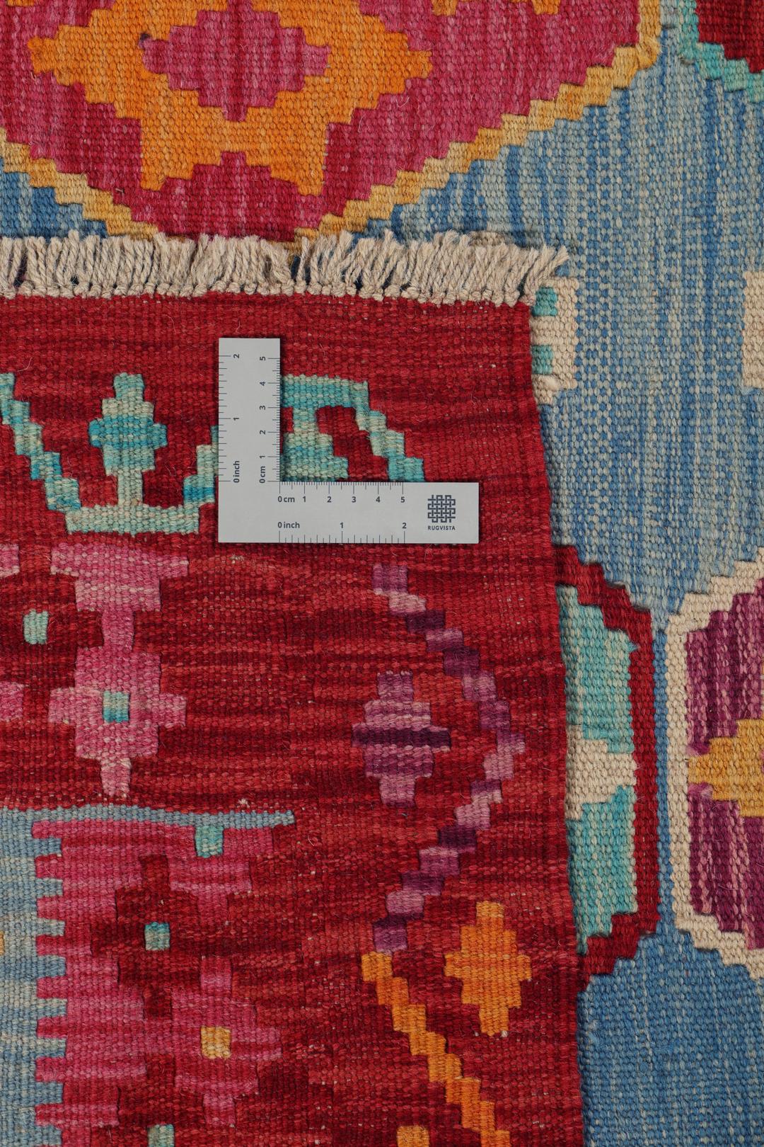 Et håndvævet Kelim Afghan Old Style-tæppe med farverige geometriske mønstre på en blå baggrund.