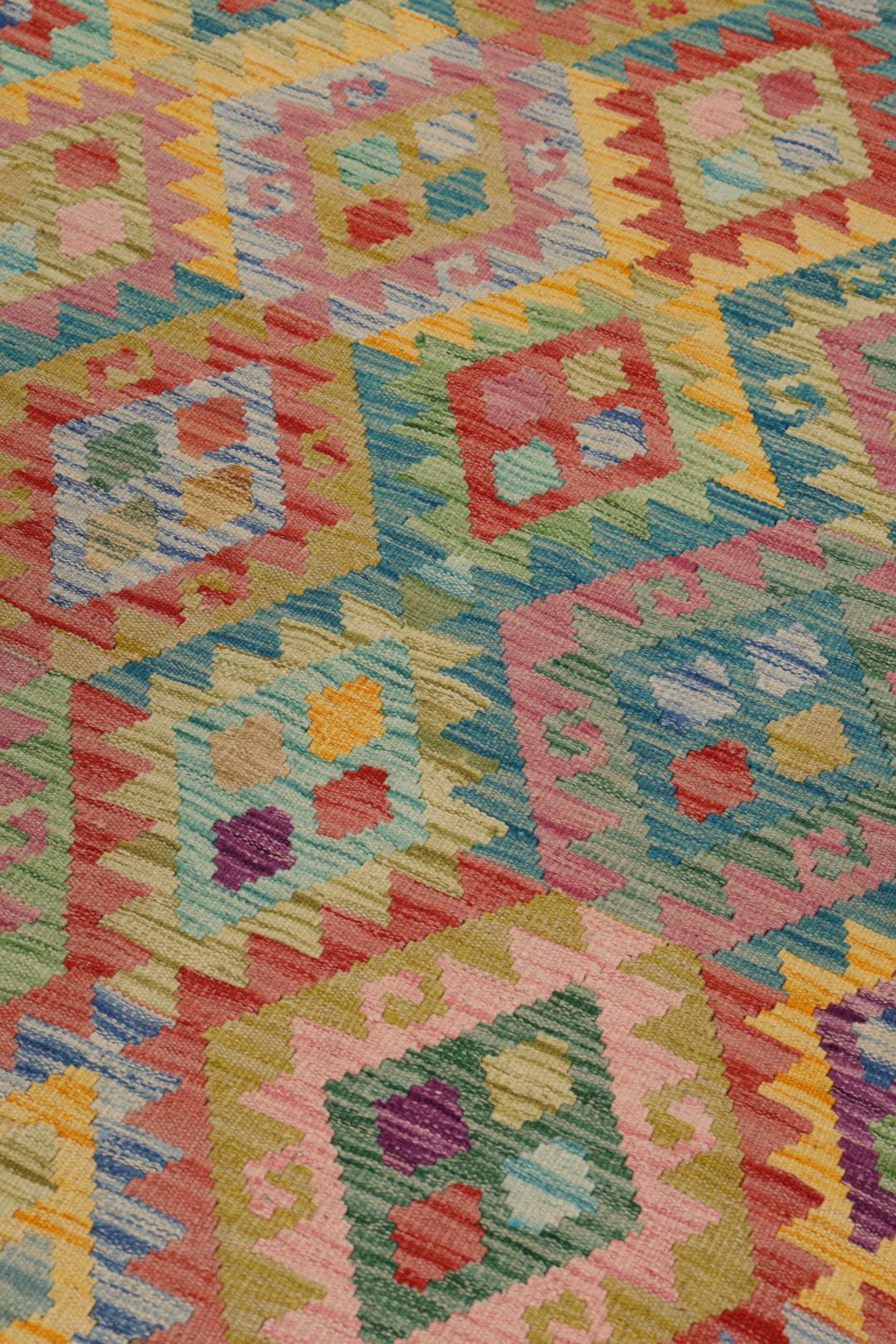 A vibrant, hand-woven Afghan Kelim rug featuring a colourful diamond pattern