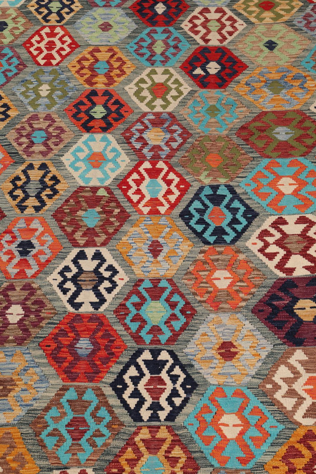 A vibrant Afghan Kelim rug with geometric patterns in multicoloured Wool.