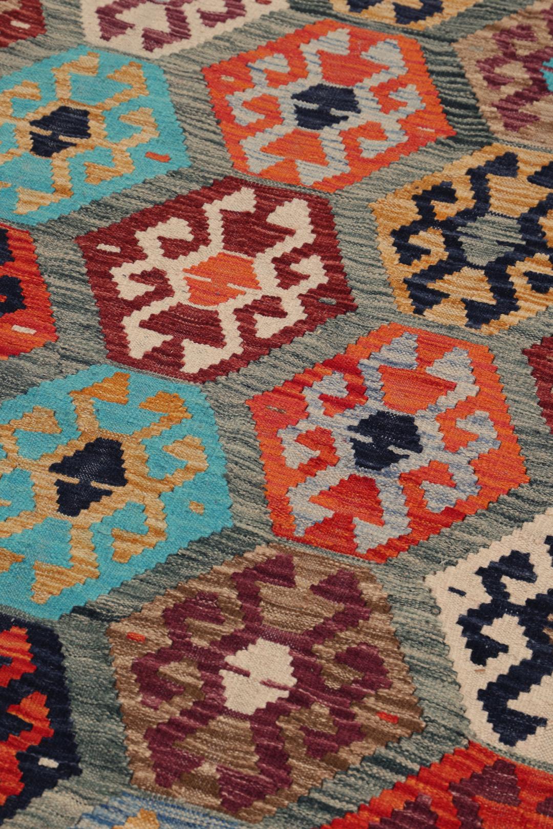A vibrant Afghan Kelim rug with geometric patterns in multicoloured Wool.
