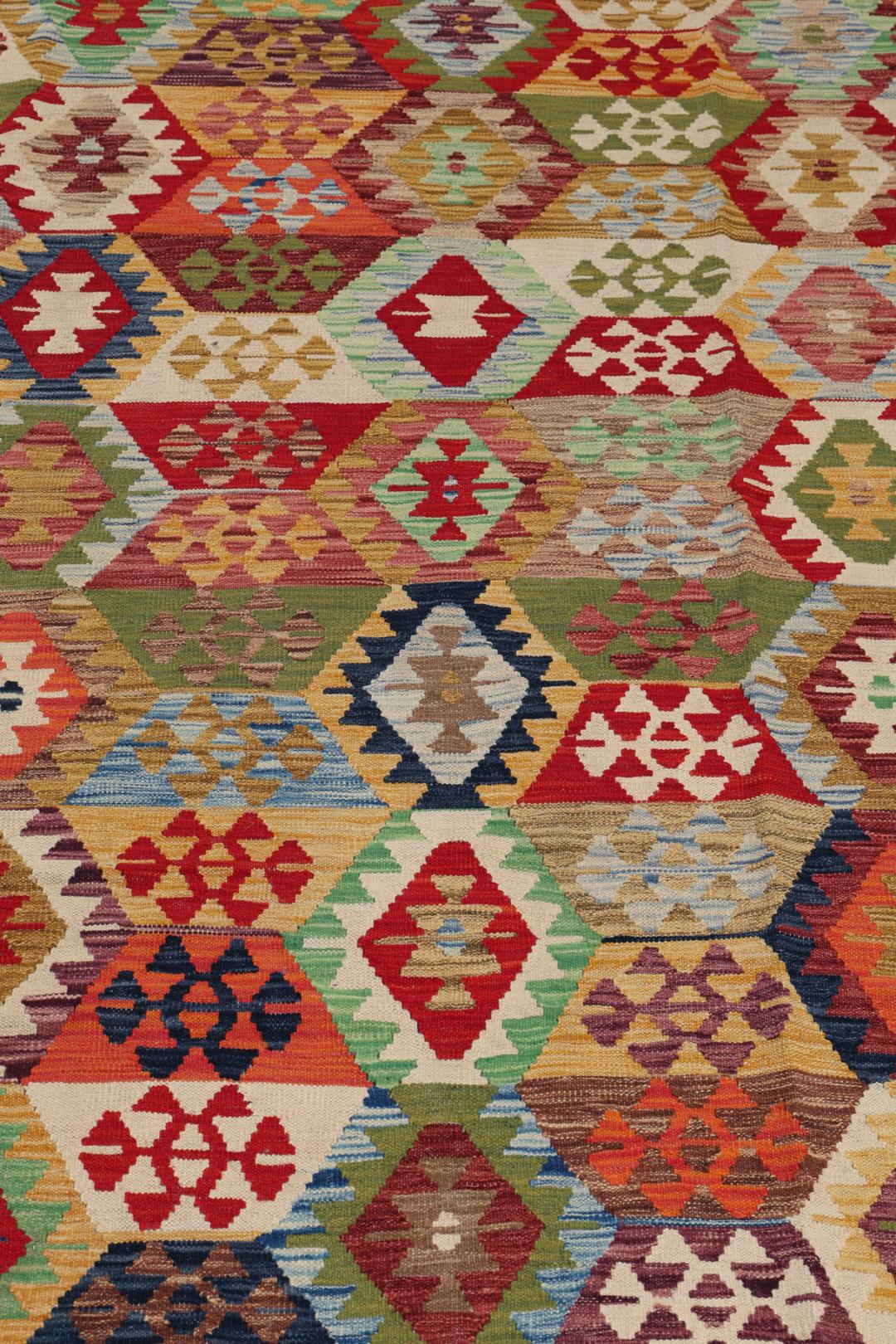 A large rectangular Afghan Kelim rug featuring a vibrant multicolor geometric pattern
