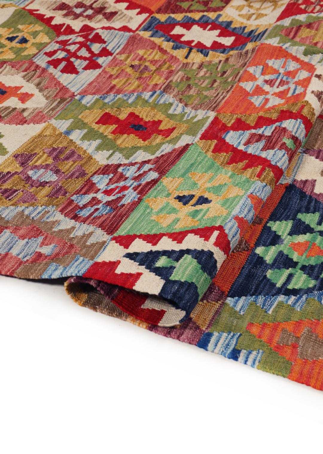 A large rectangular Afghan Kelim rug featuring a vibrant multicolor geometric pattern