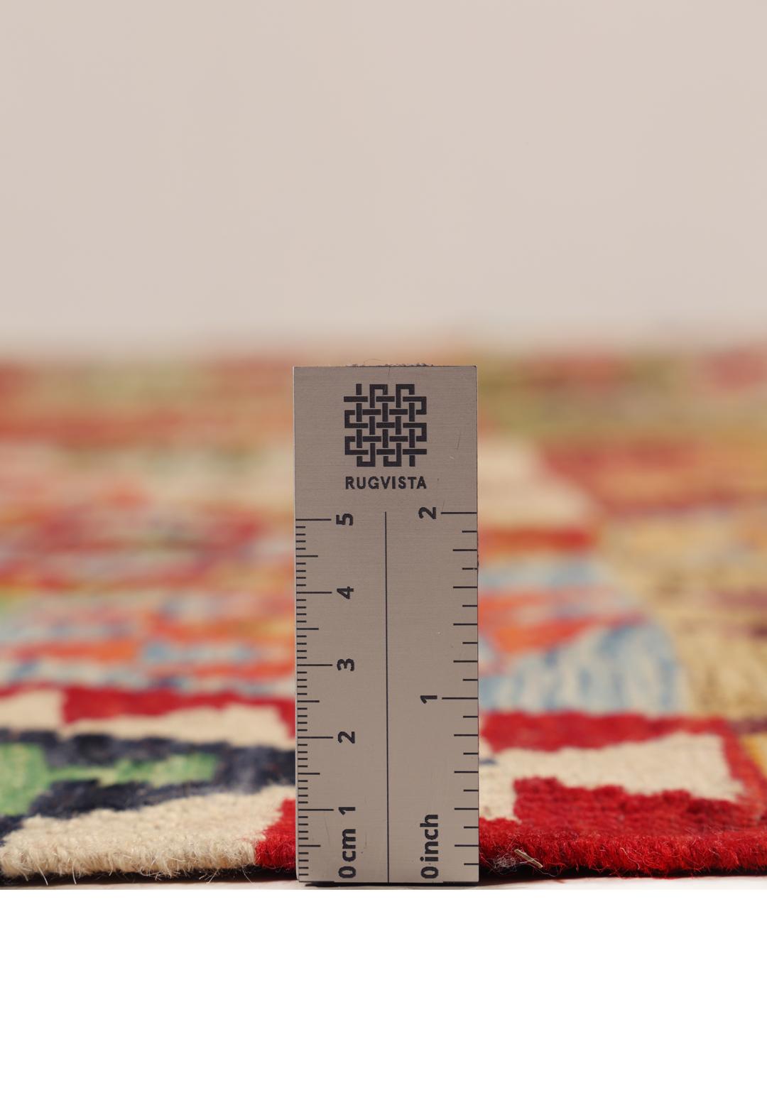 A large rectangular Afghan Kelim rug featuring a vibrant multicolor geometric pattern
