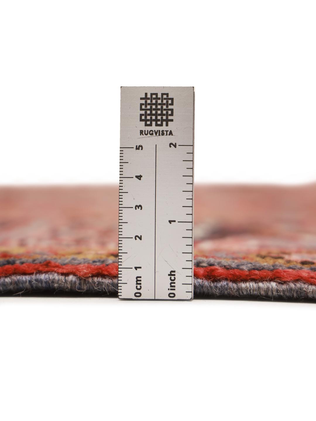 Een groot, handgeknoopt Heriz tapijt met een gedurfd geometrisch medaillon in dieprode en donkere tinten, afkomstig uit het Midden-Oosten.