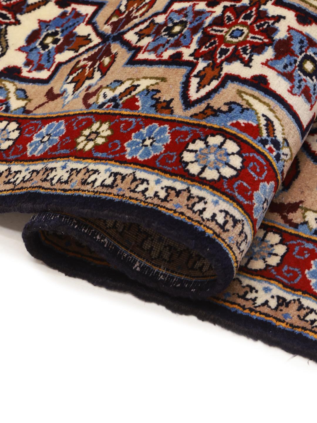 Een handgeknoopt Najafabad-tapijt uit het Midden-Oosten in tinten beige, blauw en rood.