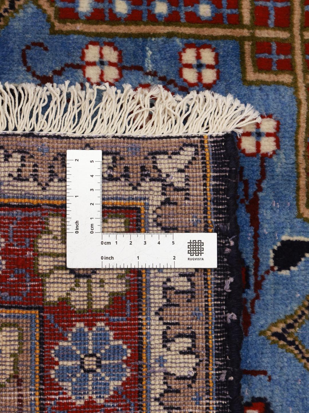 Een handgeknoopt Najafabad-tapijt uit het Midden-Oosten in tinten beige, blauw en rood.