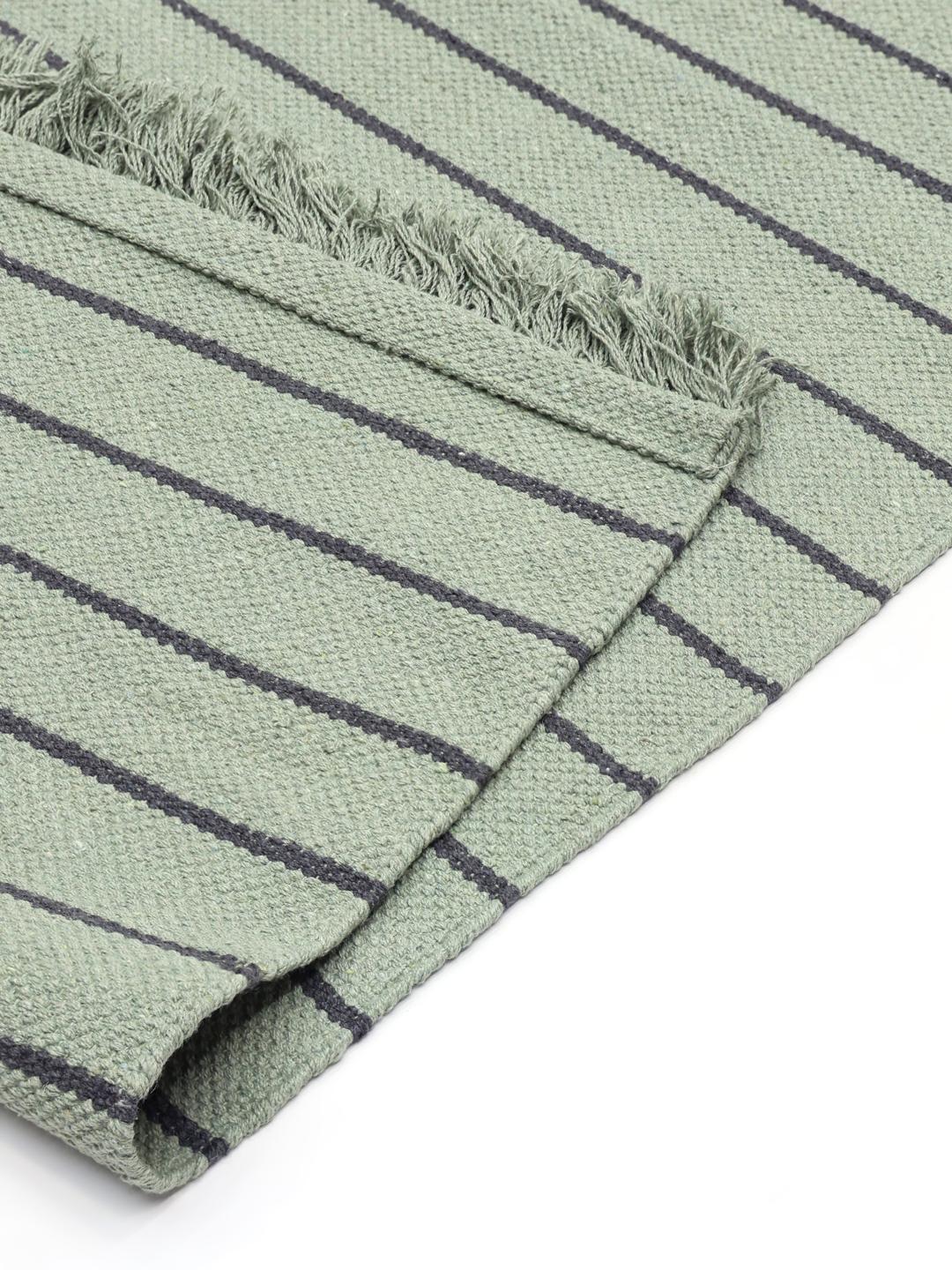Tapis vert avec des rayures gris foncé et des bordures à franges